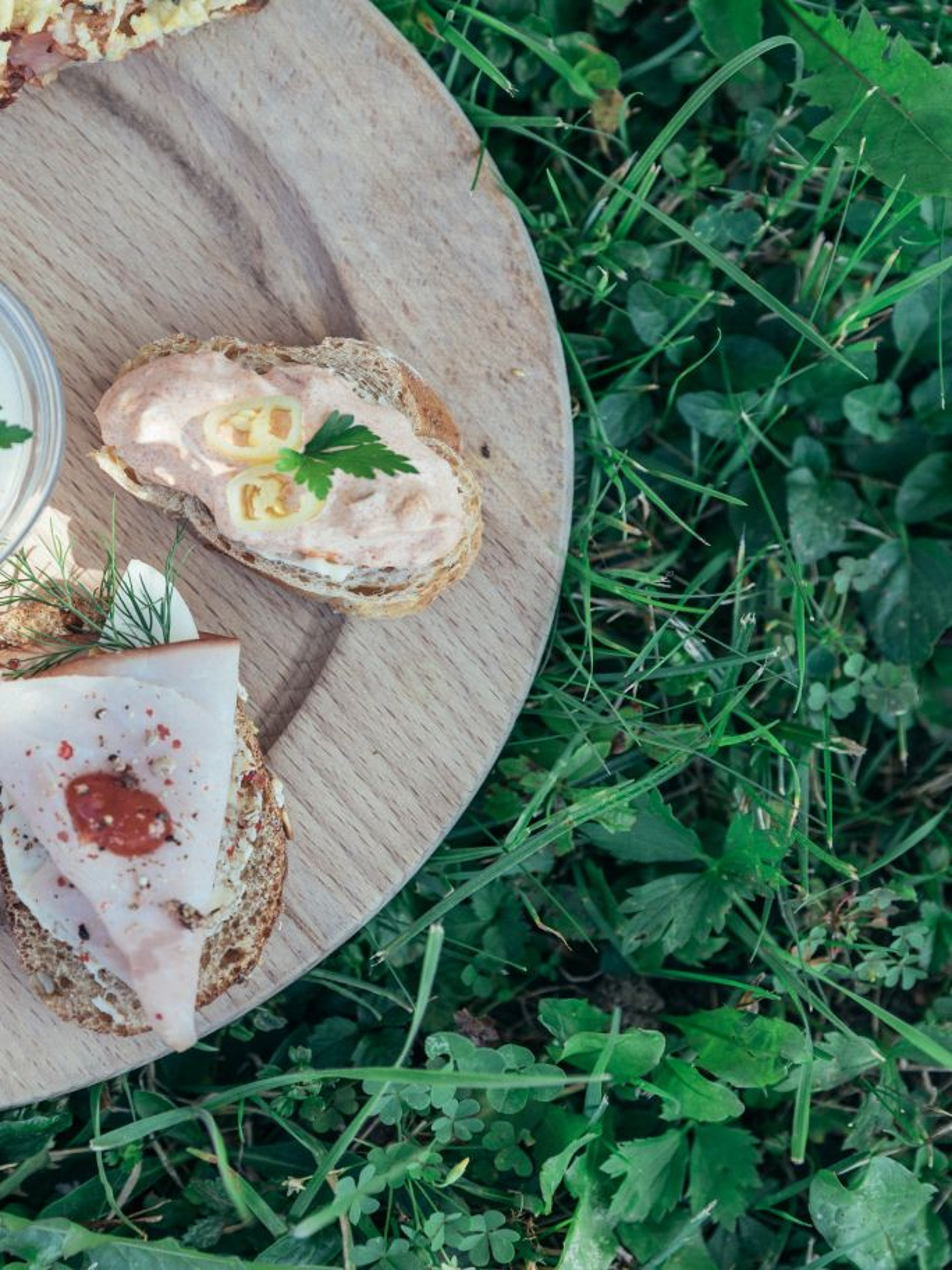 Ein Brett in der Wiese mit belegten Broten.