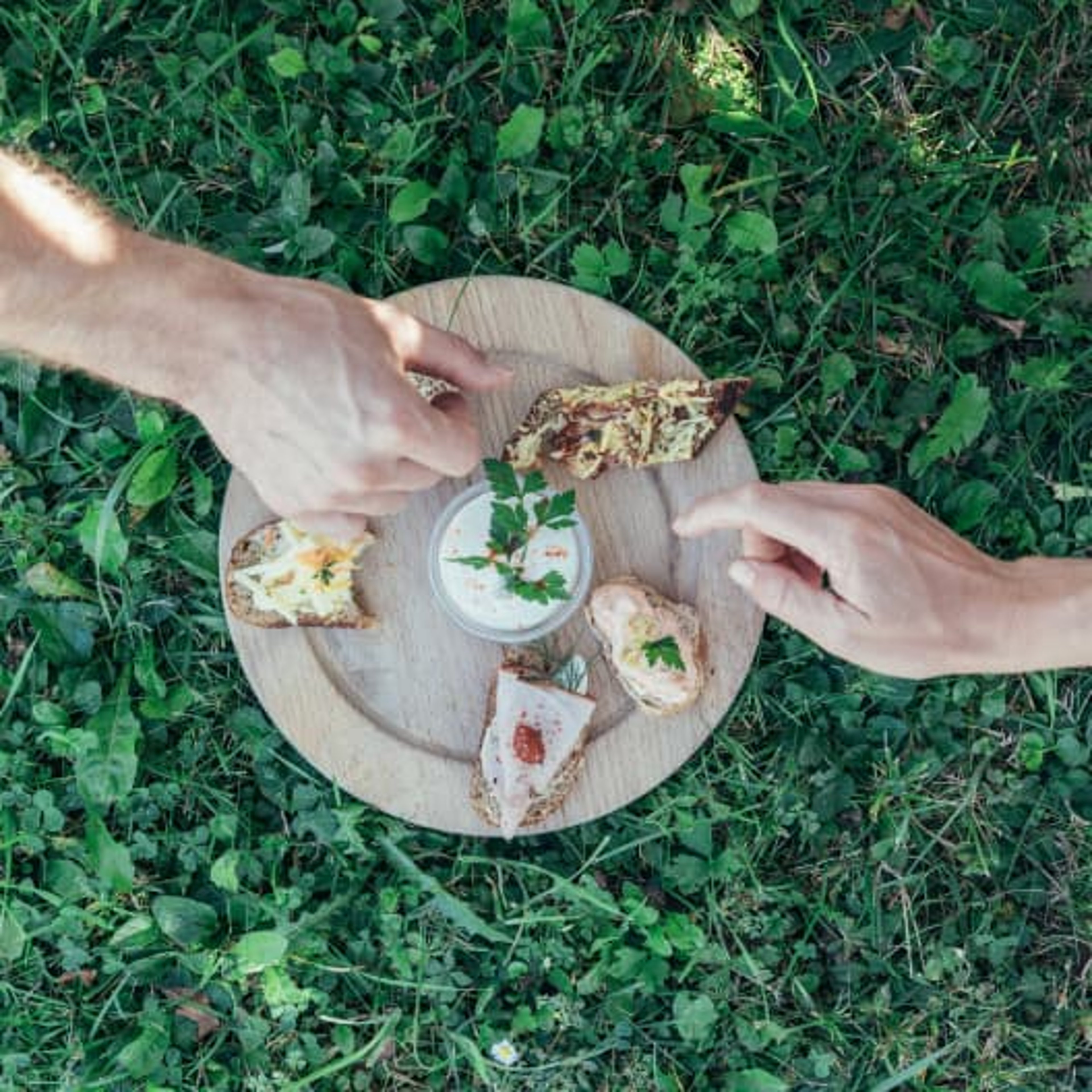 Zwei Hände greifen nach den verschieden belegten Brötchen
