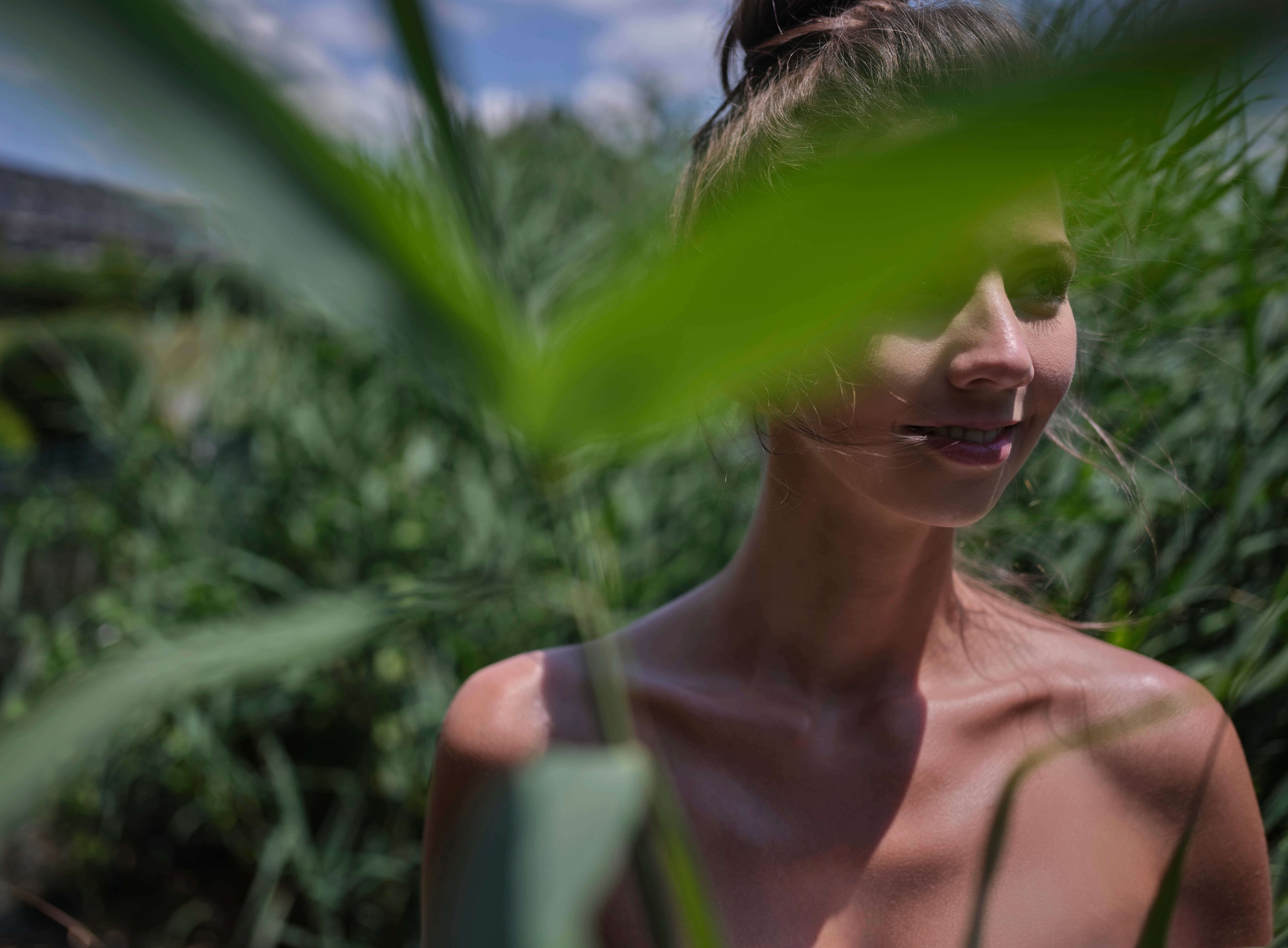 A woman is half covered by a branch.