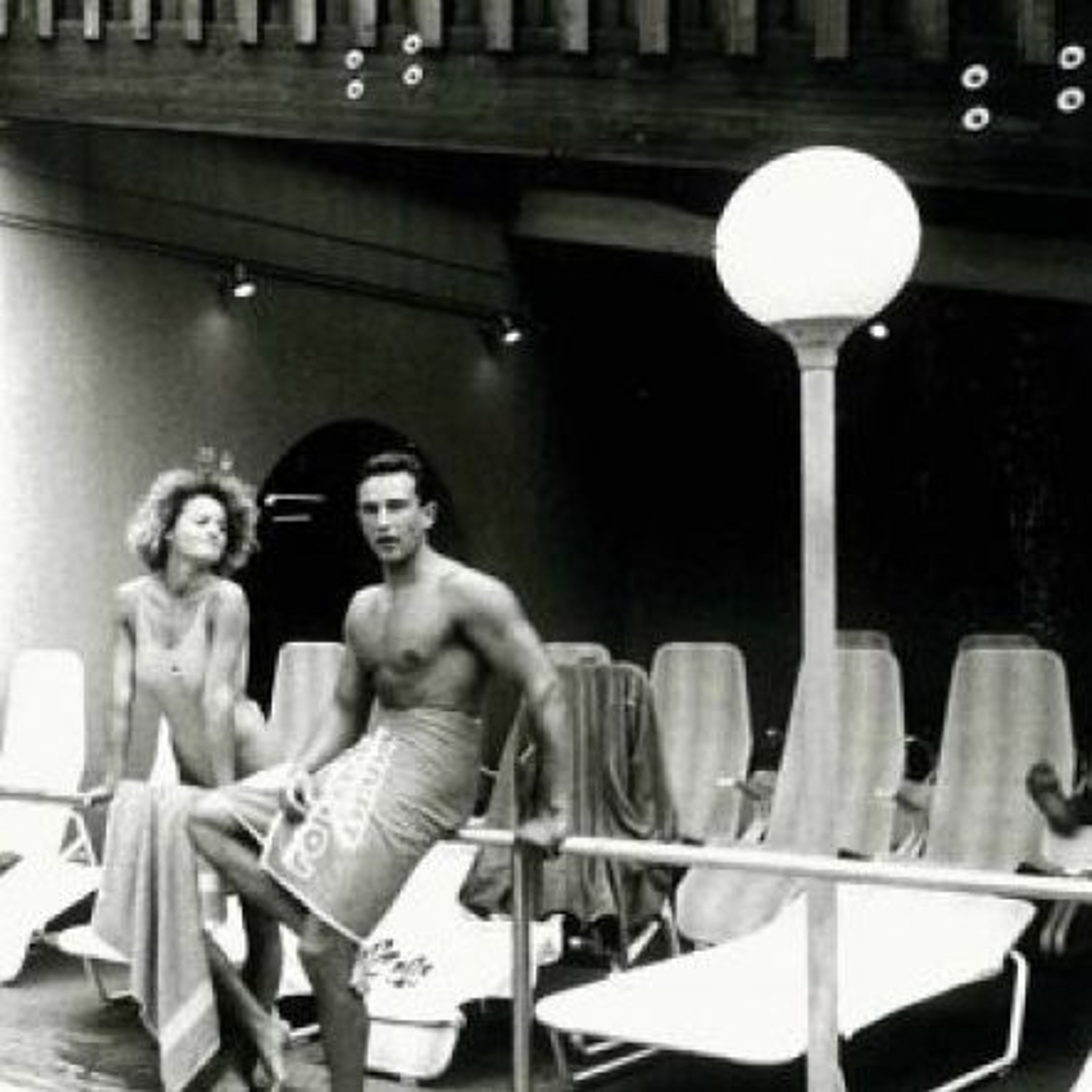 Ein Foto in schwarzweiß zeigt ein Pärchen am Beckenrand in den 80ern.