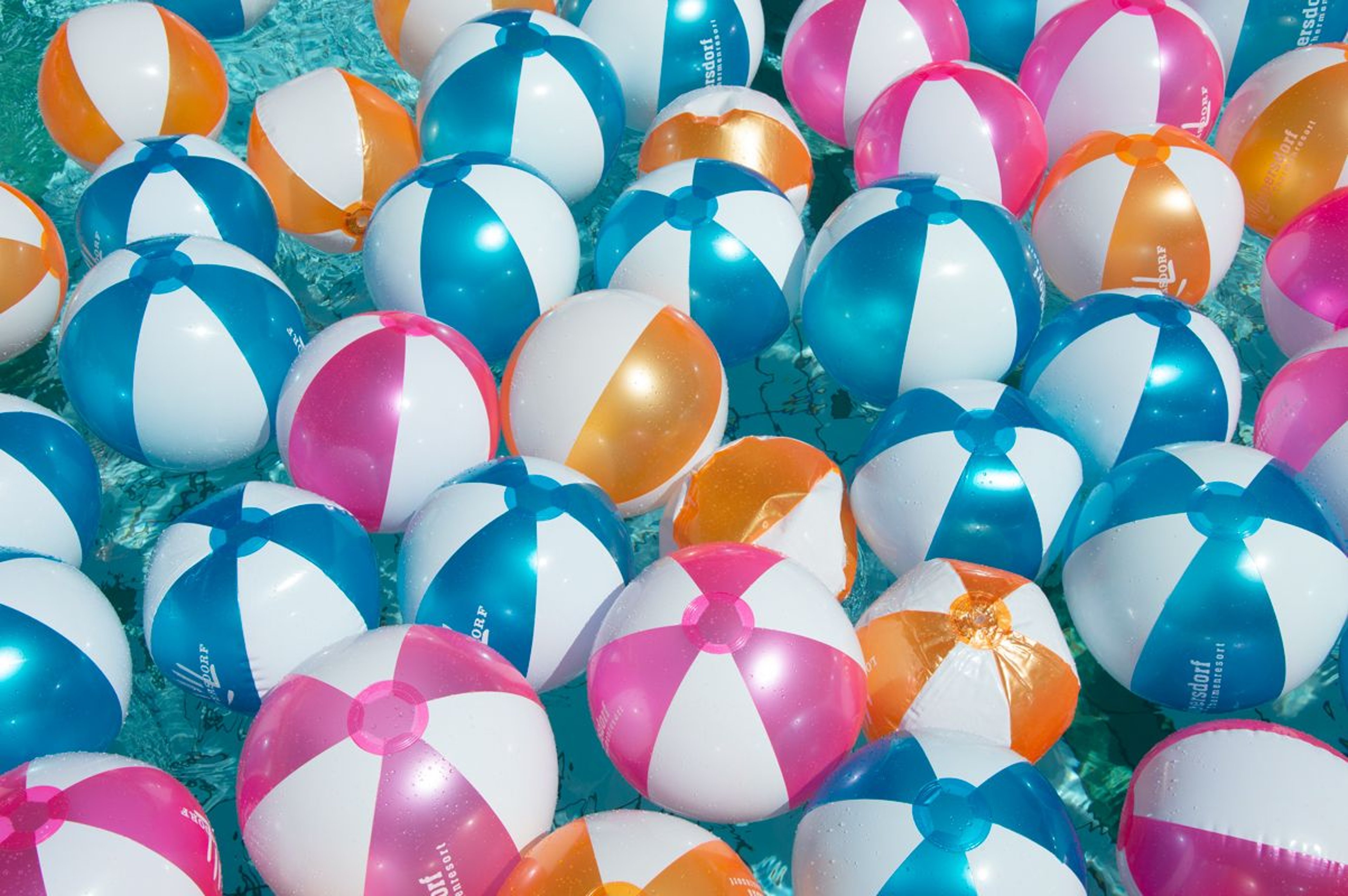 Lots of colorful beach balls floating in the water