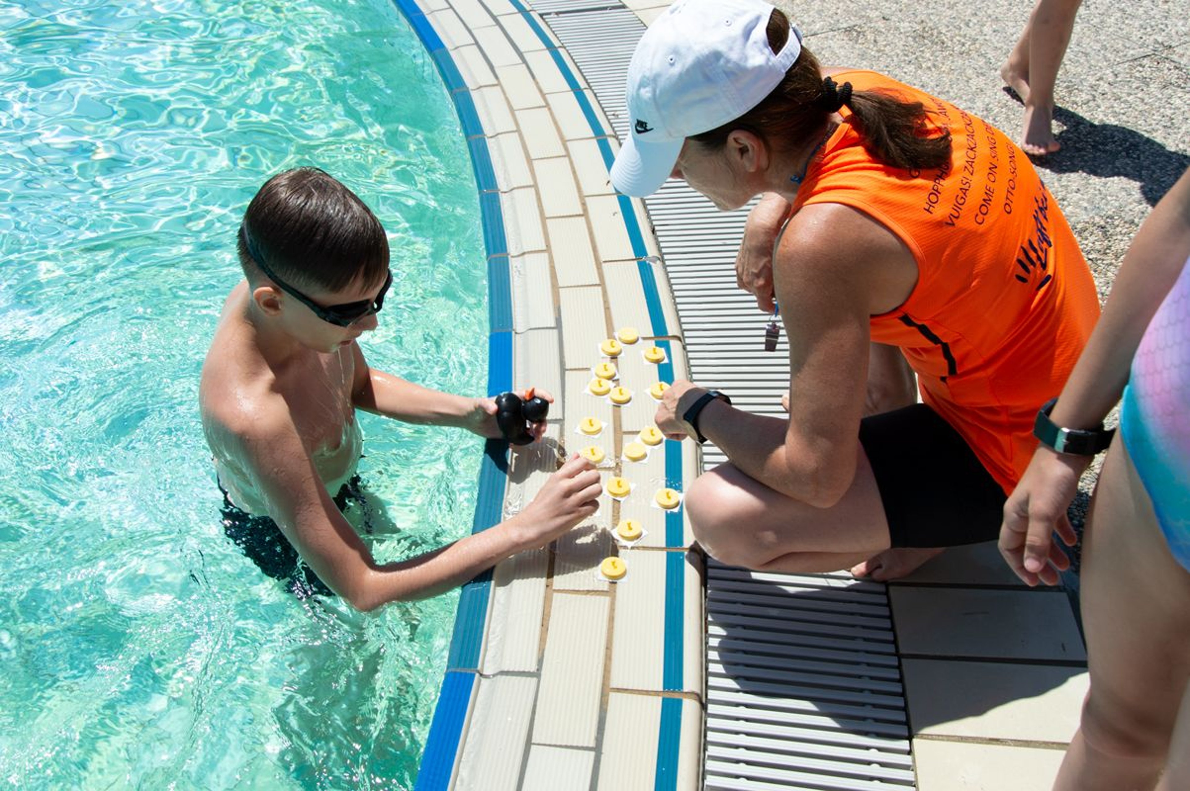 Child is in the water and tries to solve the entertainer's task
