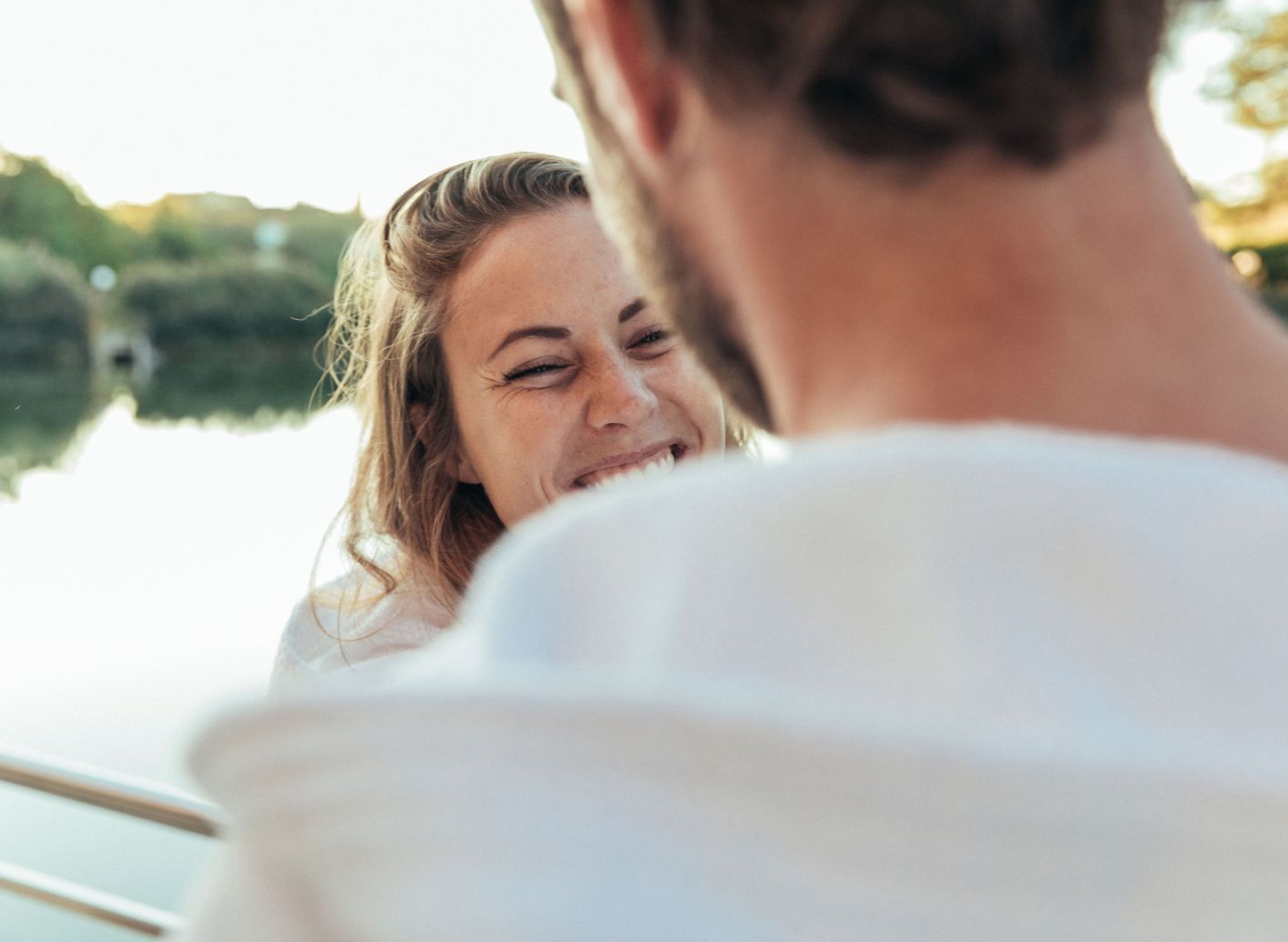 Ein lachendes Paar vor dem Naturteich des Schaffelbads des Thermenresort Loipersdorf.