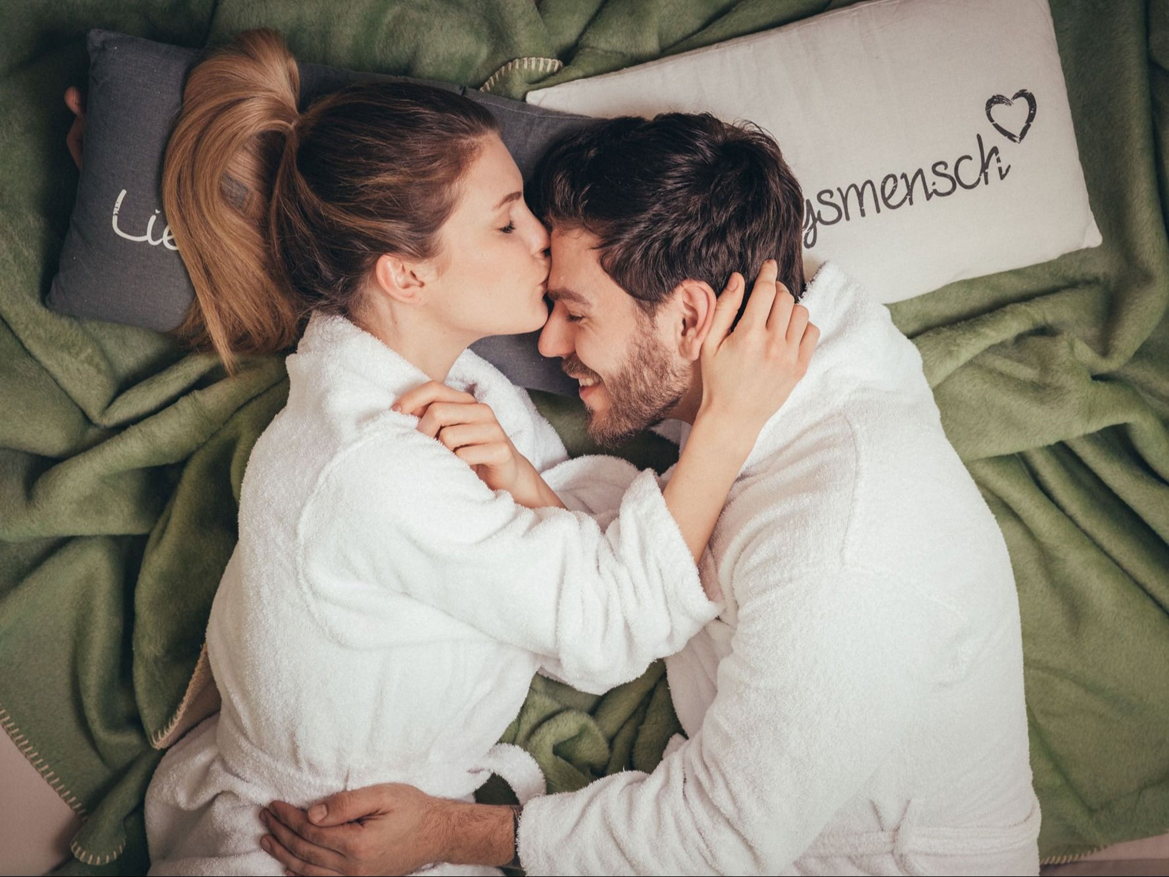 Woman in love kisses man on the forehead.