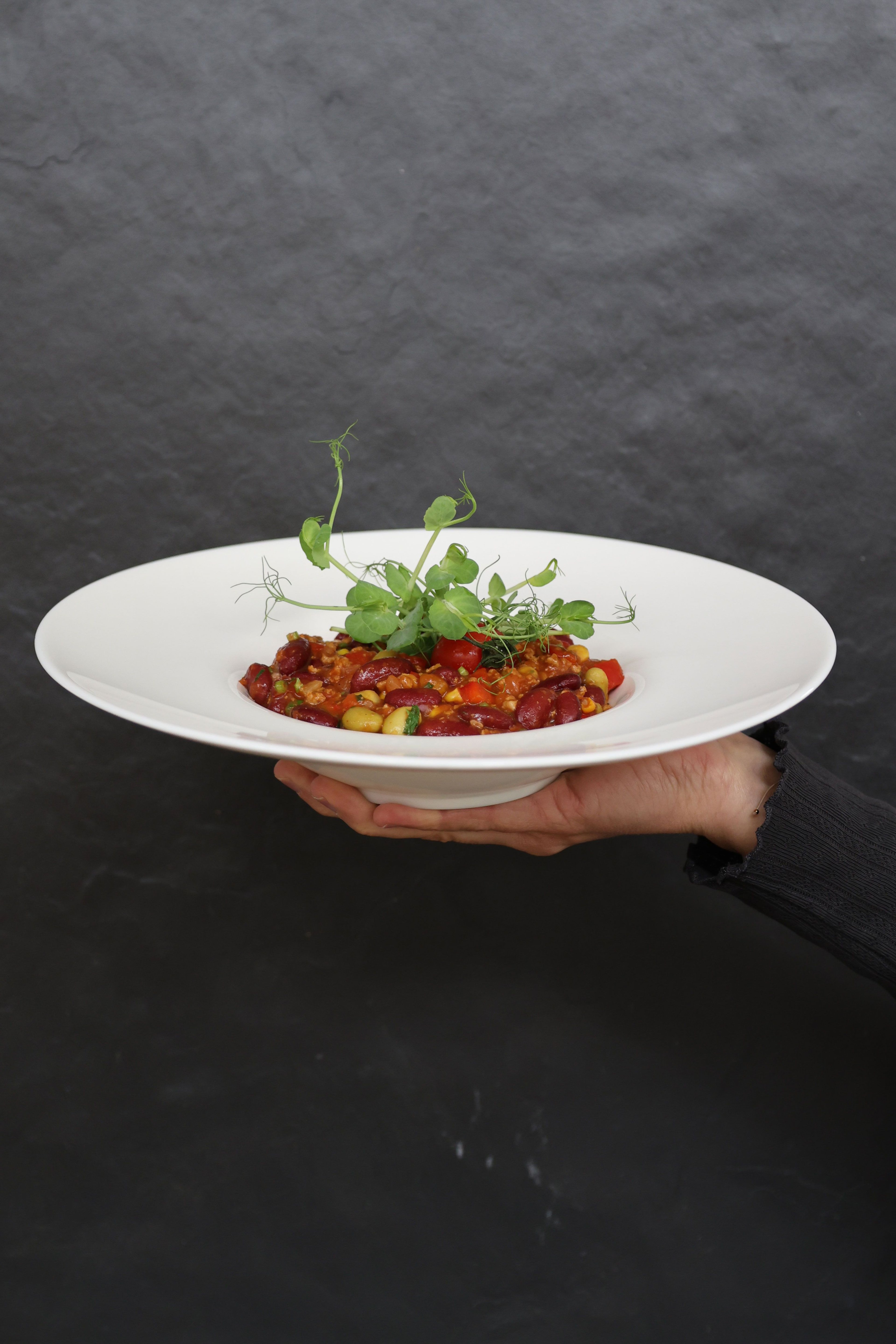 Chilli sin Carne on a plate. This is held with one hand. 