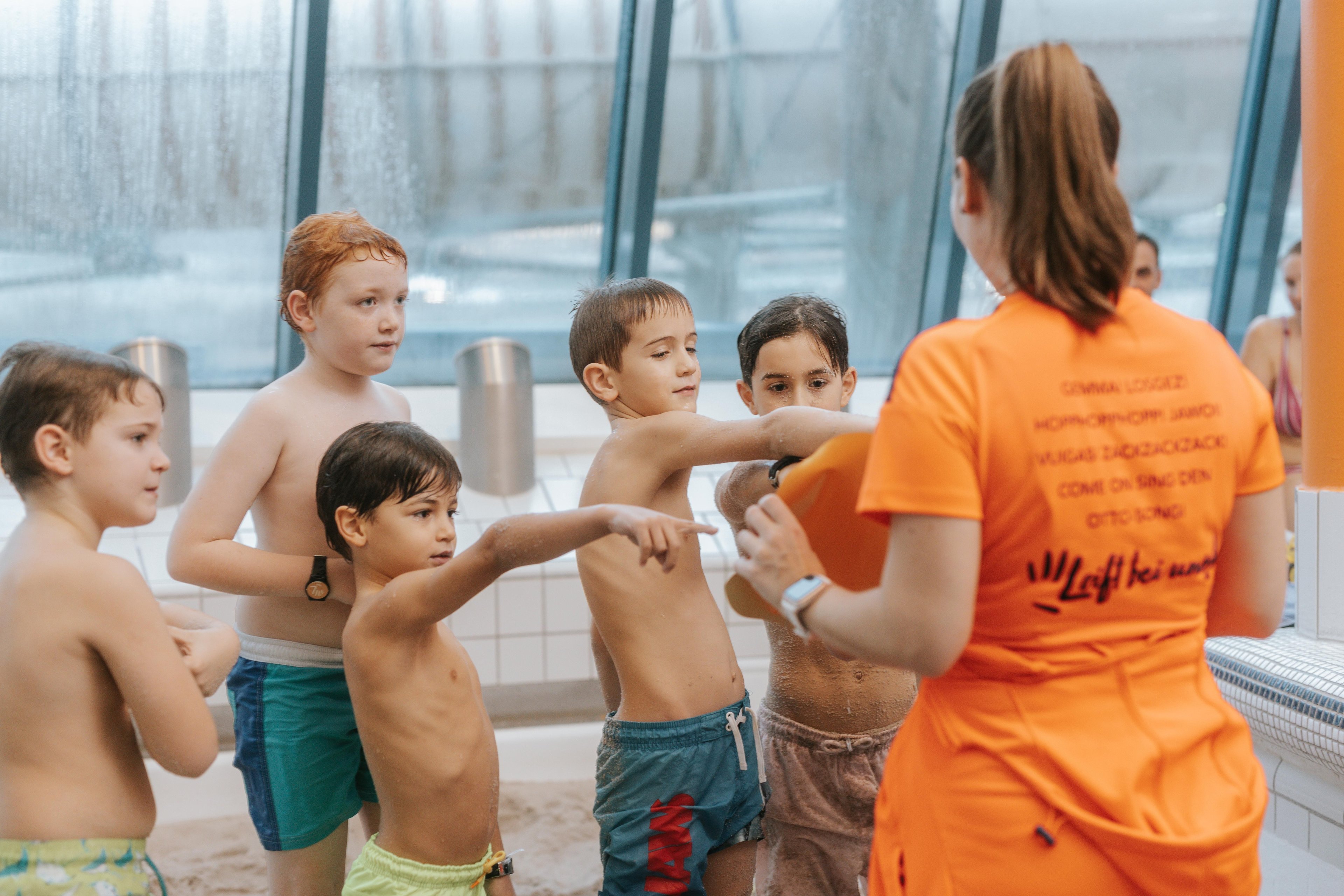Kinder zeigen bei einem Animations-Mitarbeiter auf eine Karte. 