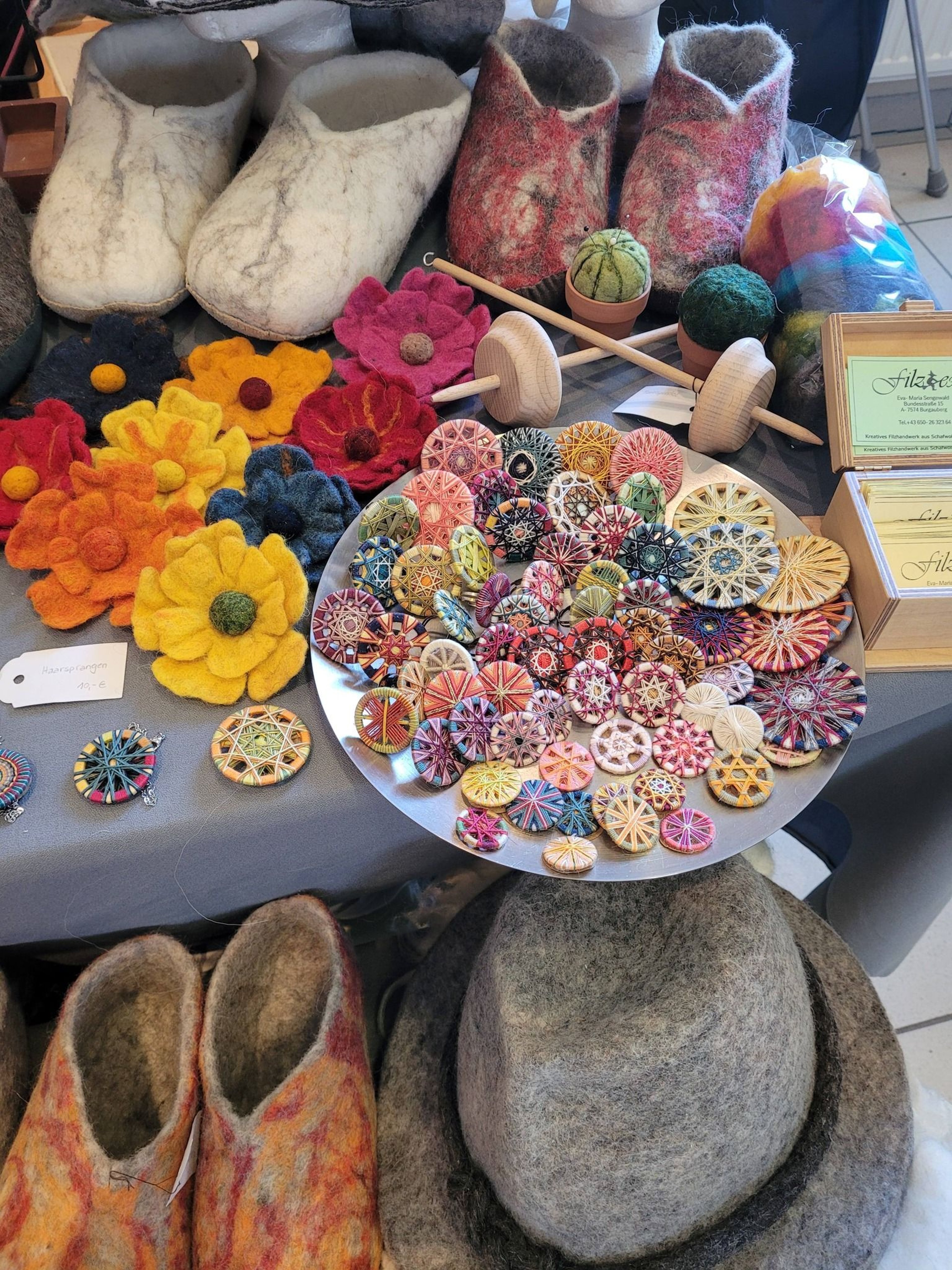 Bunte Filzarbeiten, handgefertigte Anhänger, Blumen und traditionelle Handspindeln