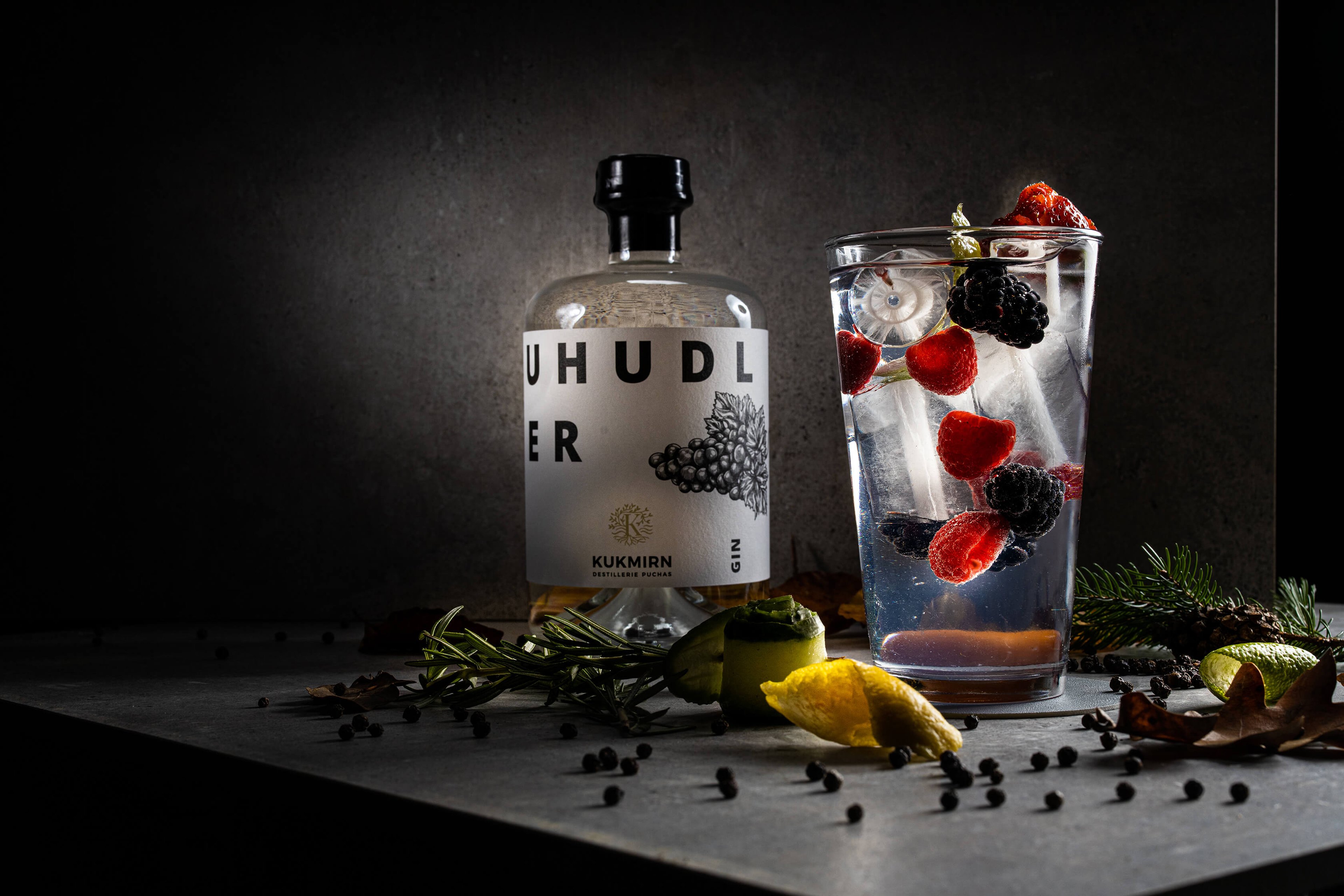 Ein Glas Gin Tonic mit einer Flasche Uhudlergin.