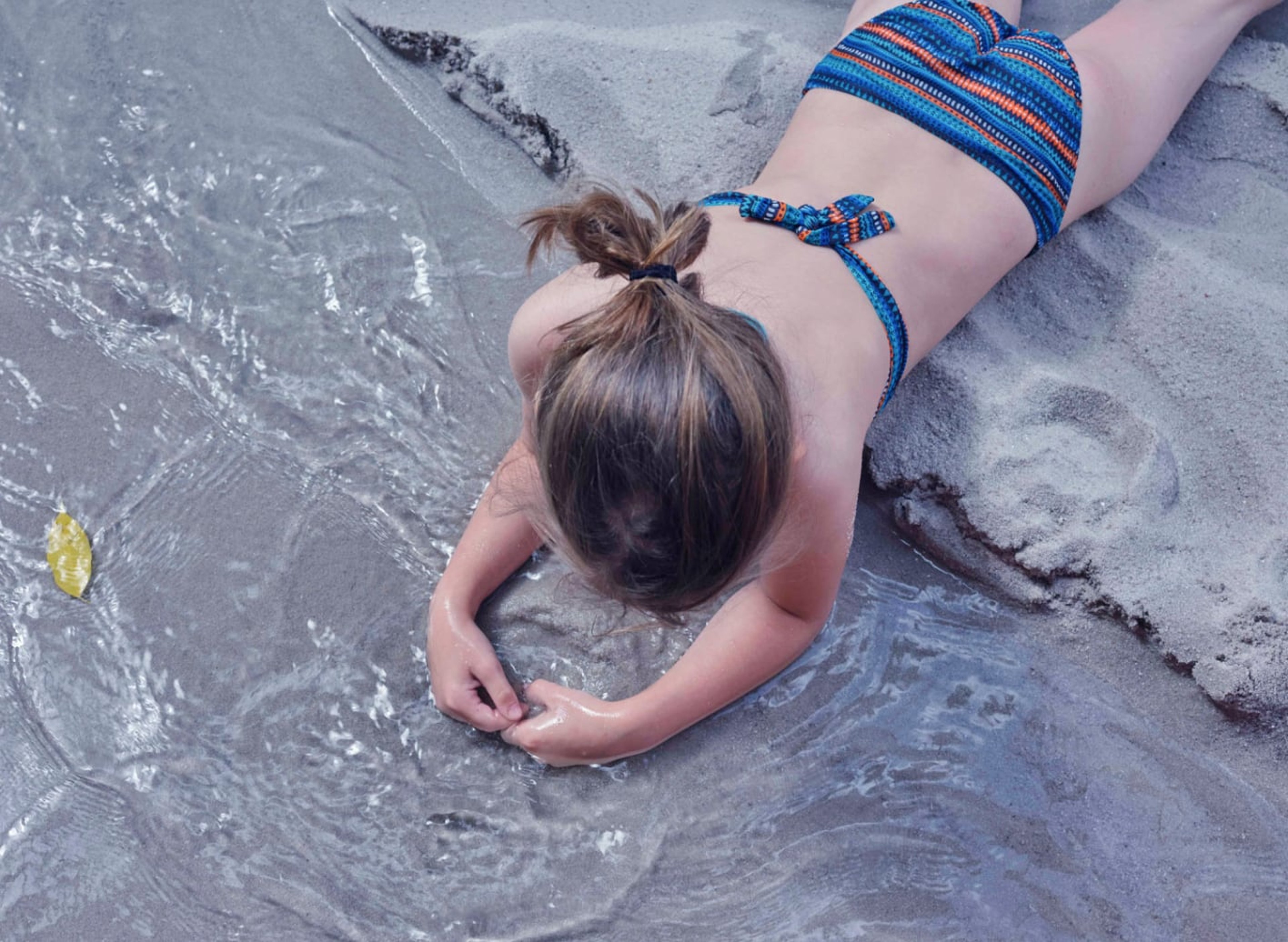 Kind spielt mit dem Sand am Baby Beach