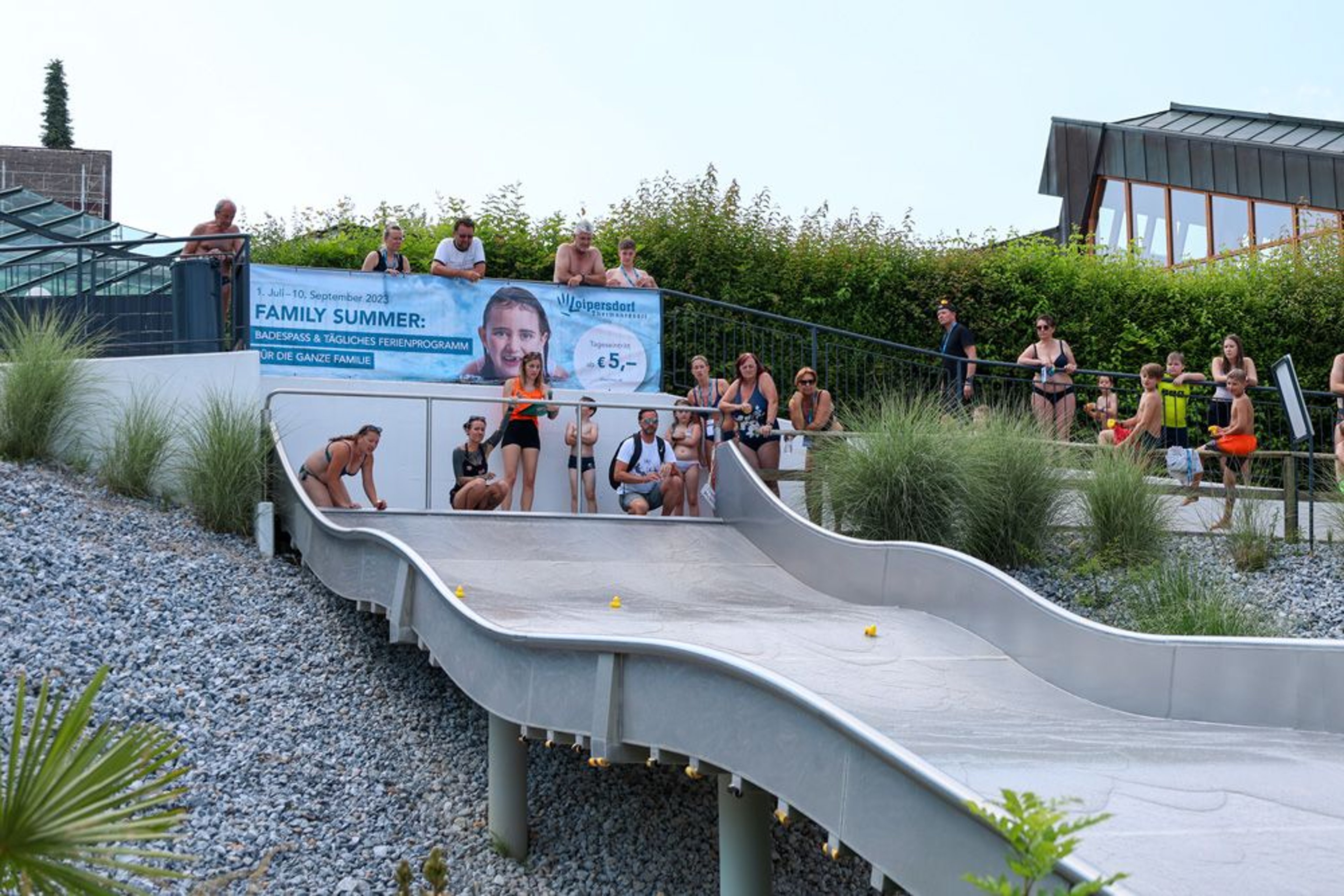 Kinder stehen bei der Breitwellenrutsche am Start