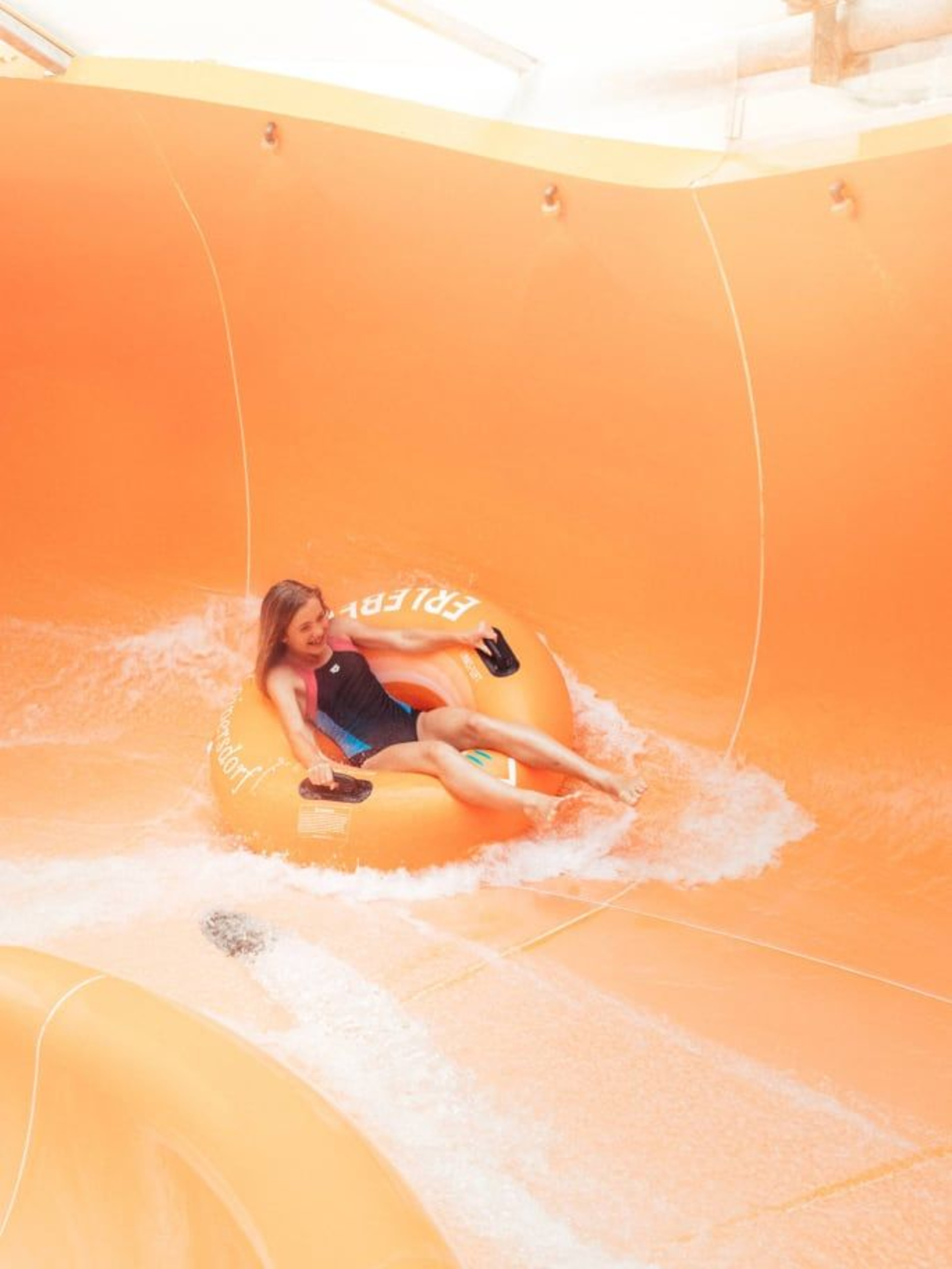 Kind rutscht in einem Reifen die Rutsche runter