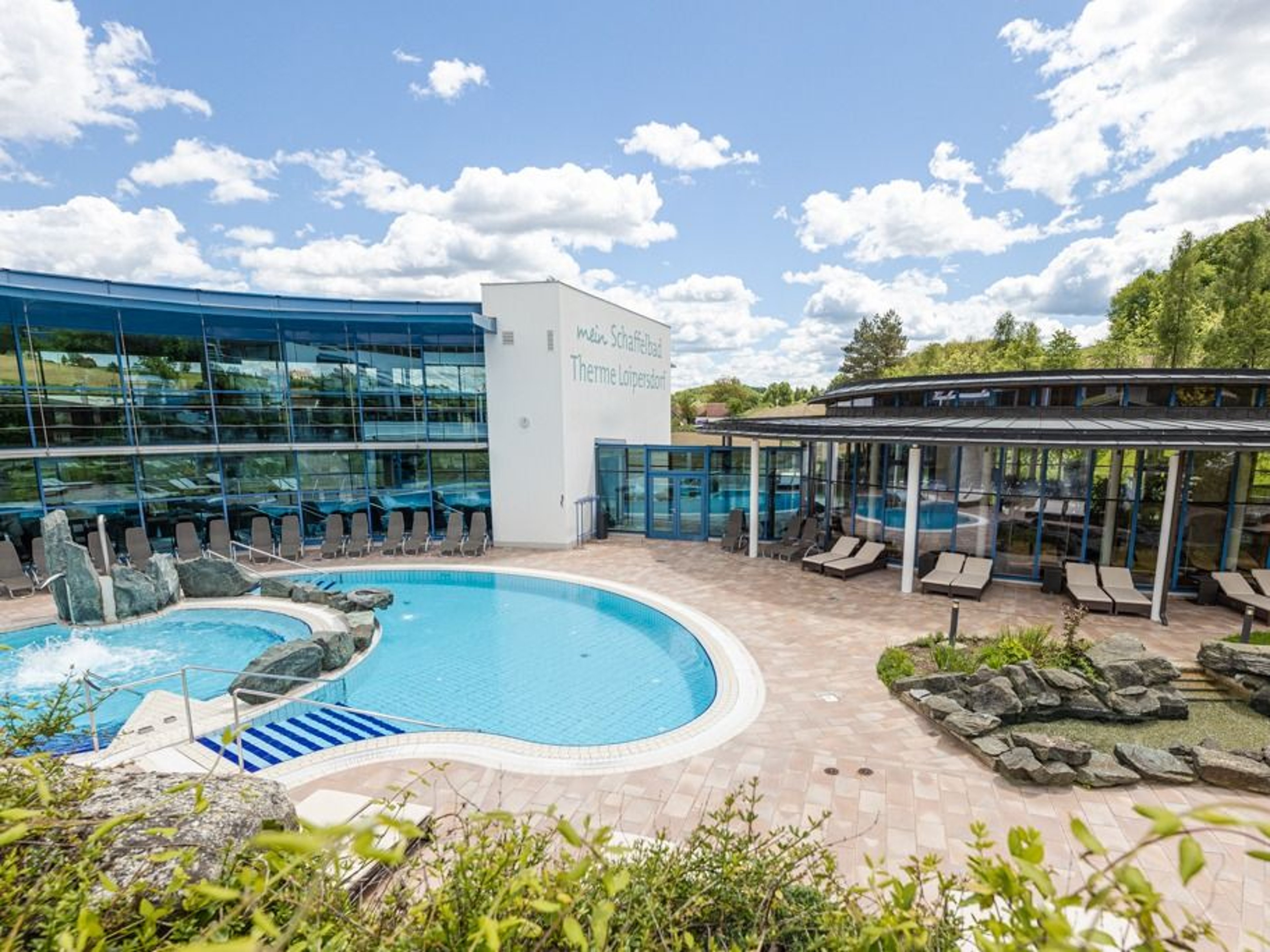 The rock pool and the lake pavilion in the Schaffelbad in the sunshine.