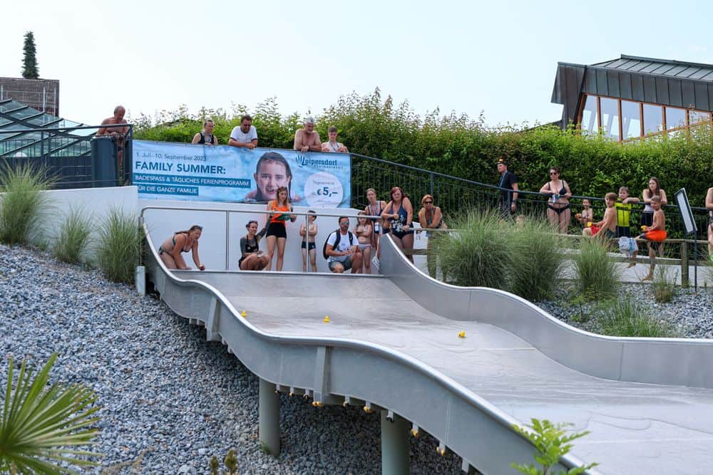 Children stand at the start of the wide wave slide