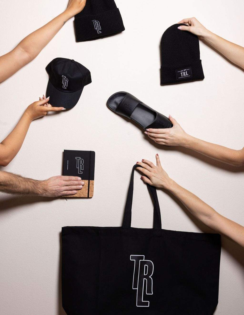 A selection of our most popular branded items is presented. Hands holding the black items in the picture.