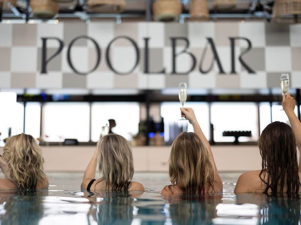 4 Damen halten ihren Drink in die Luft.