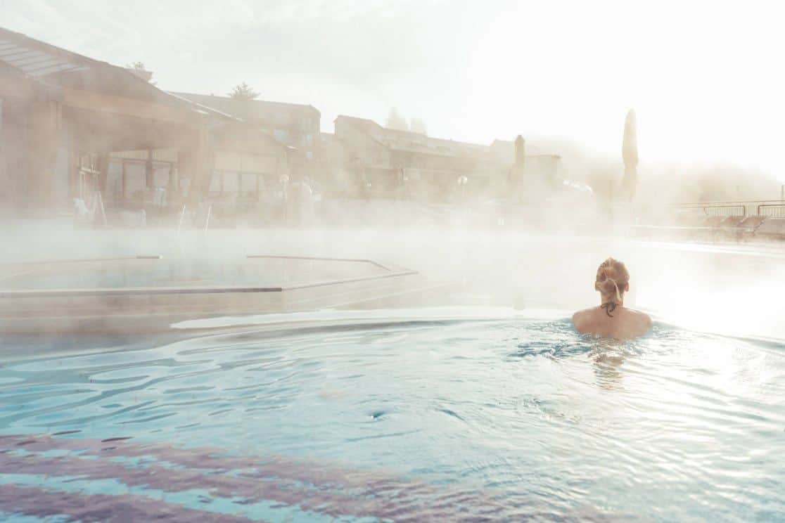 Frau schwimmt im Dampfenden Thermalwasser
