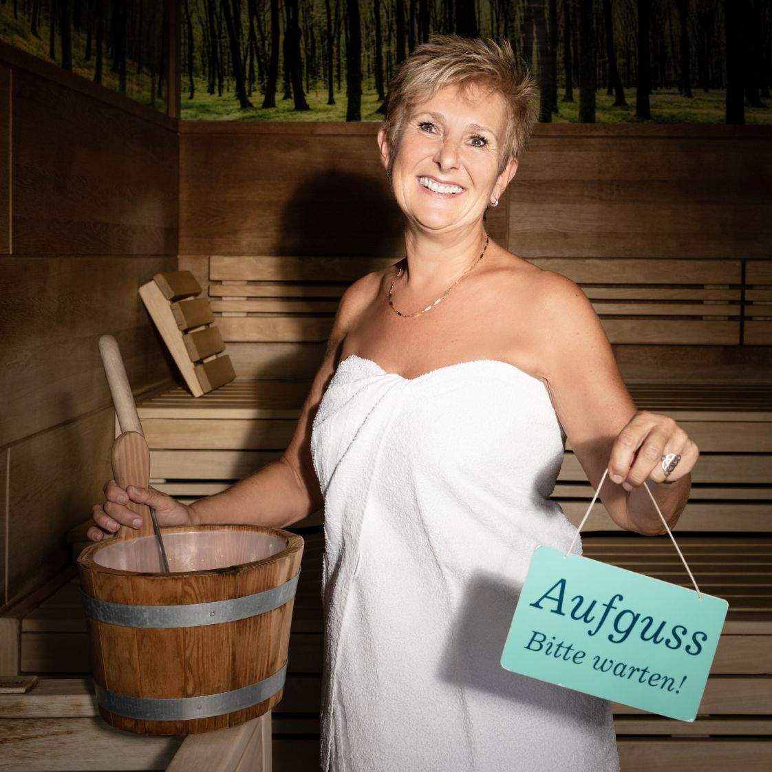 Eine Saunameisterin bereitet den Aufguss in der Sauna vor.