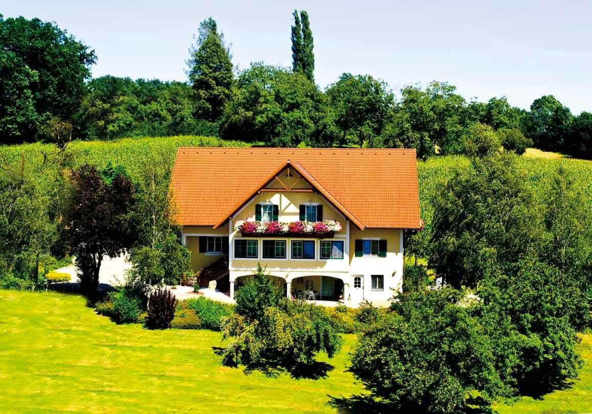 Der Sonnenhof in Unterlamm aus der Ferne eingebettet in eine Hügellandschaft.