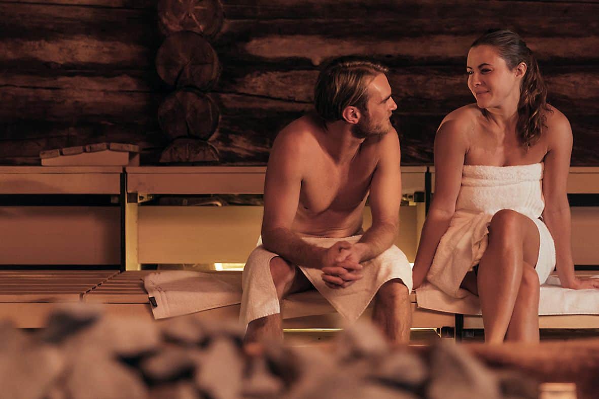 Couple sitting in the sauna and looking at each other