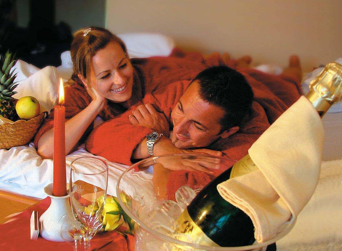 A couple cuddling in bed.