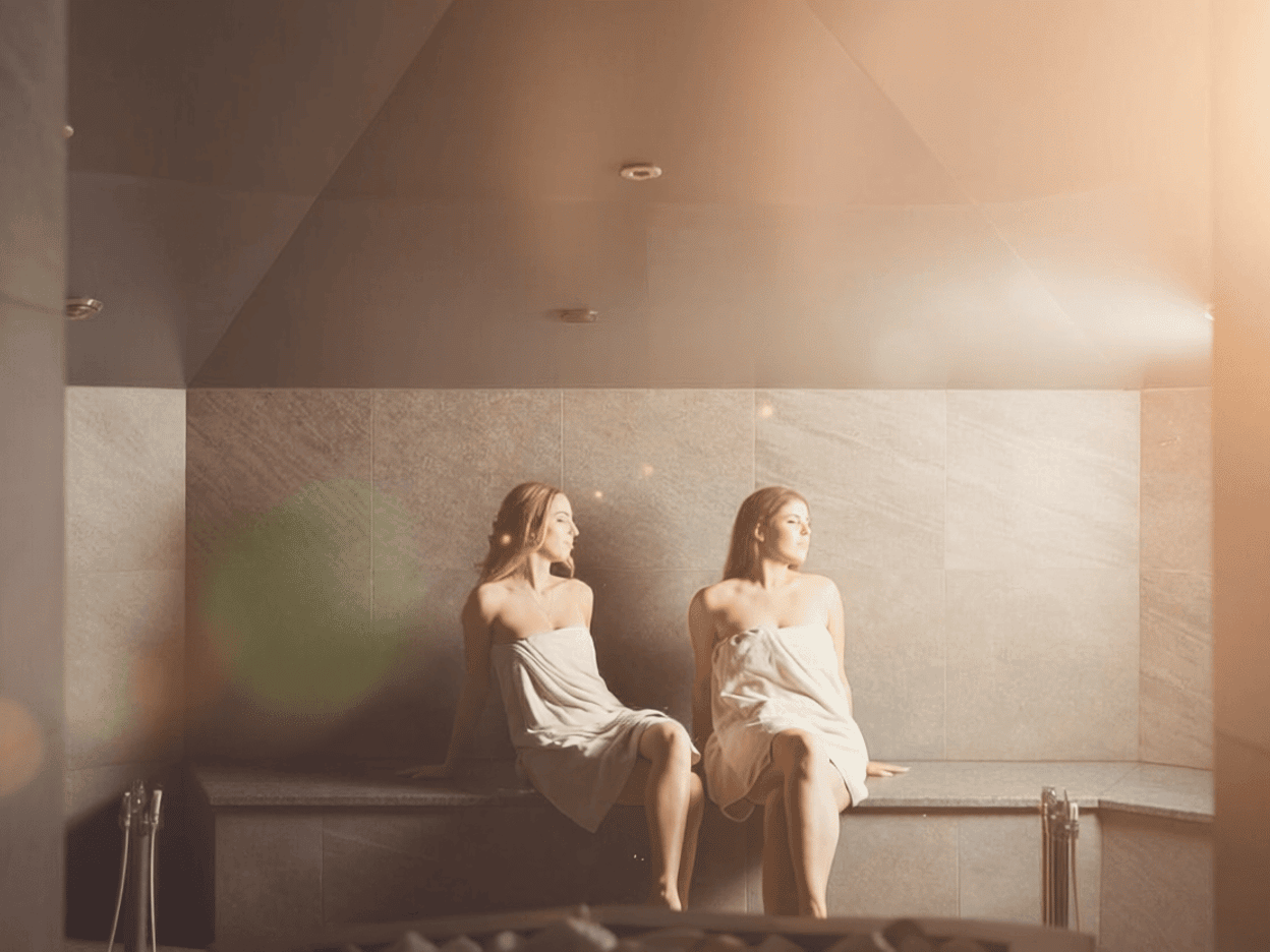 Zwei Freundinnen sitzen im Dampfbad.