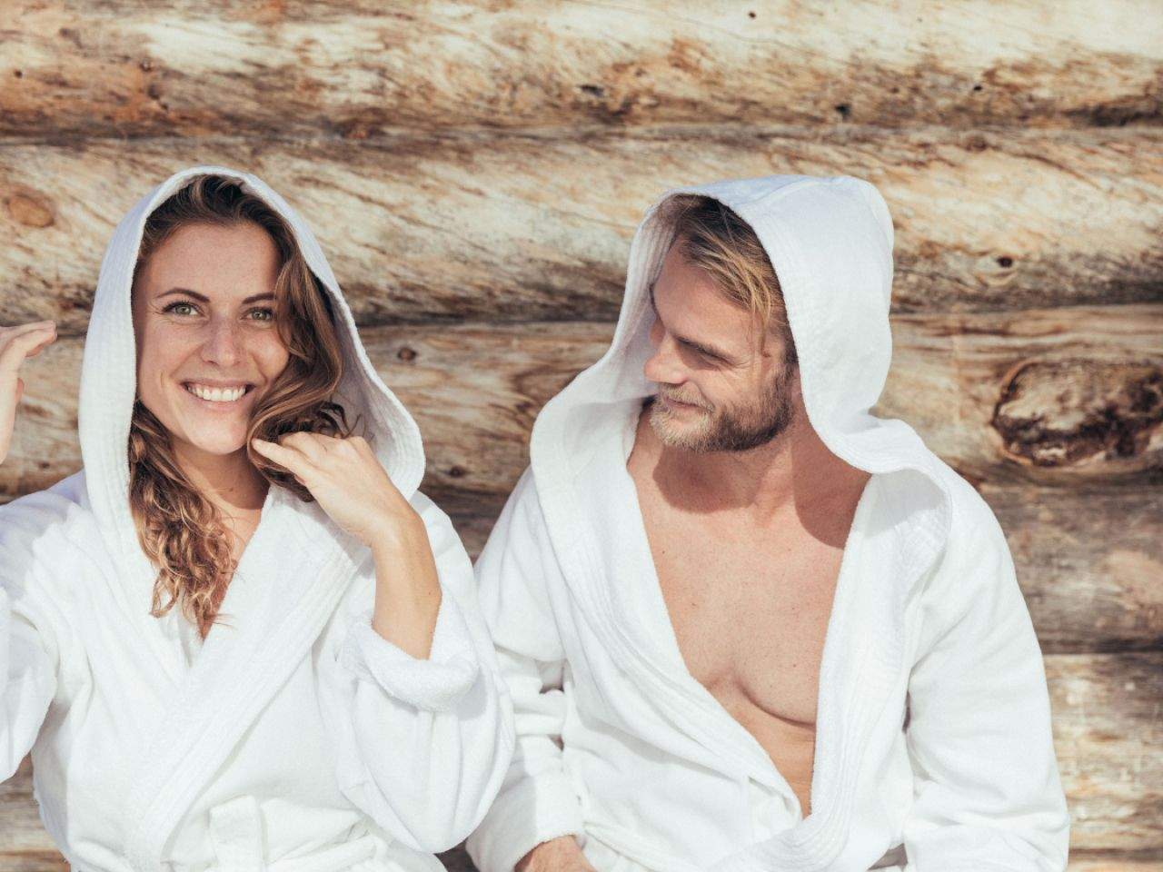 Zwei Personen sitzen im Bademantel vor einer Sauna des Thermenresort Loipersdorf.