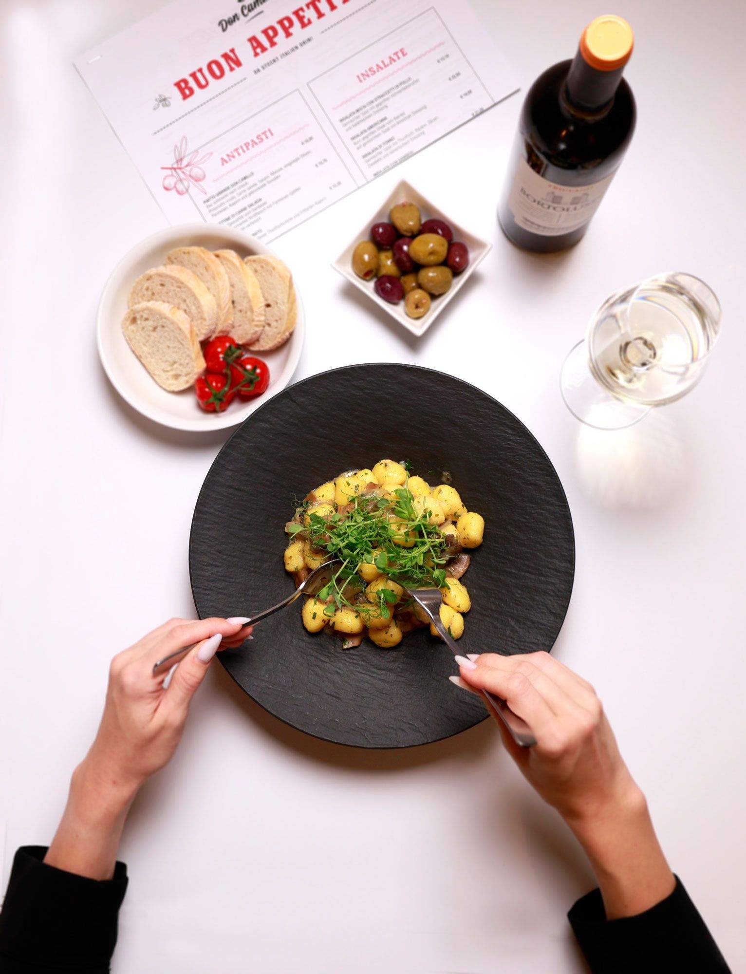 Freshly prepared polenta gnocchi on a black plate at Don Camillo in the Loipersdorf thermal spa resort.