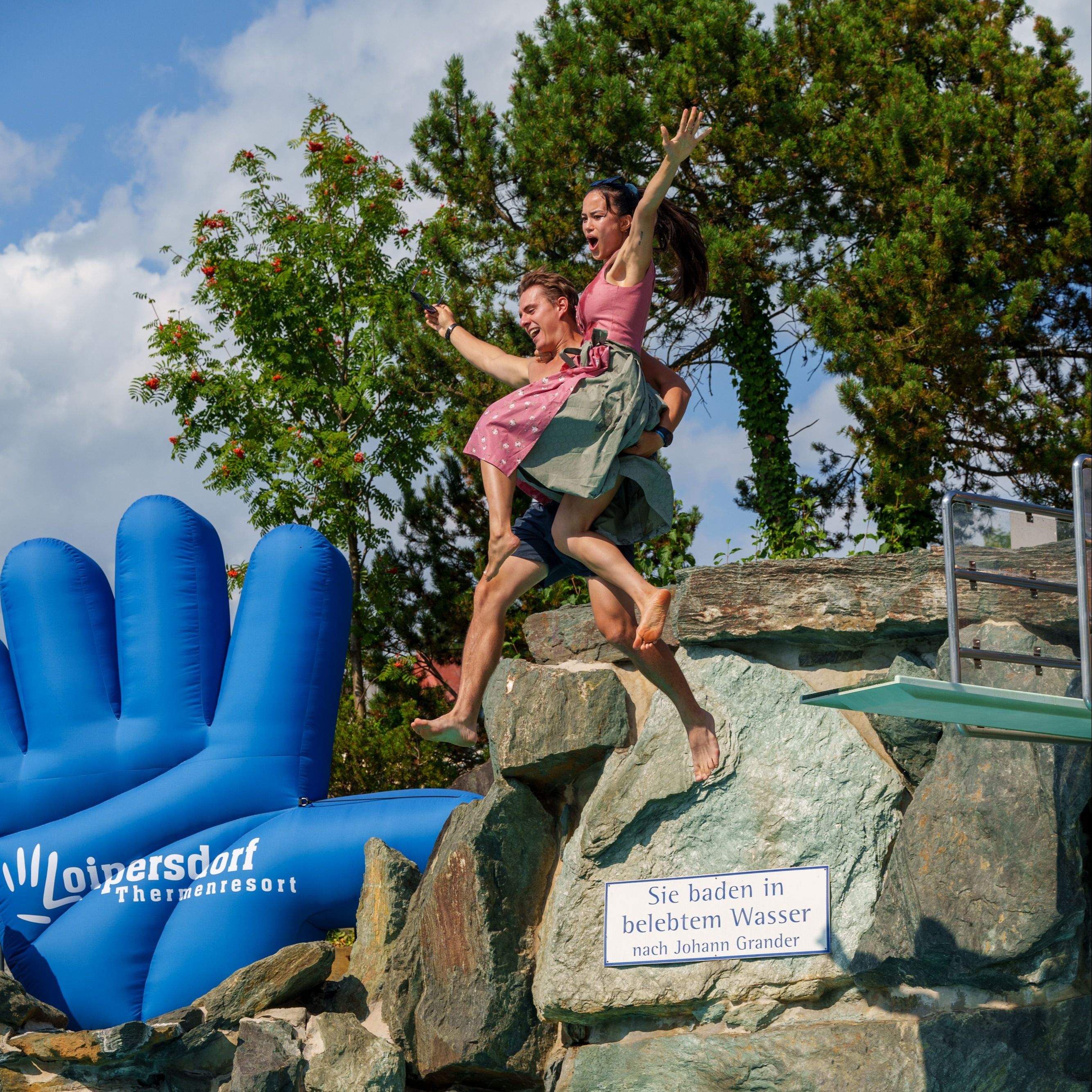 Couple in traditional costume jump from the diving tower