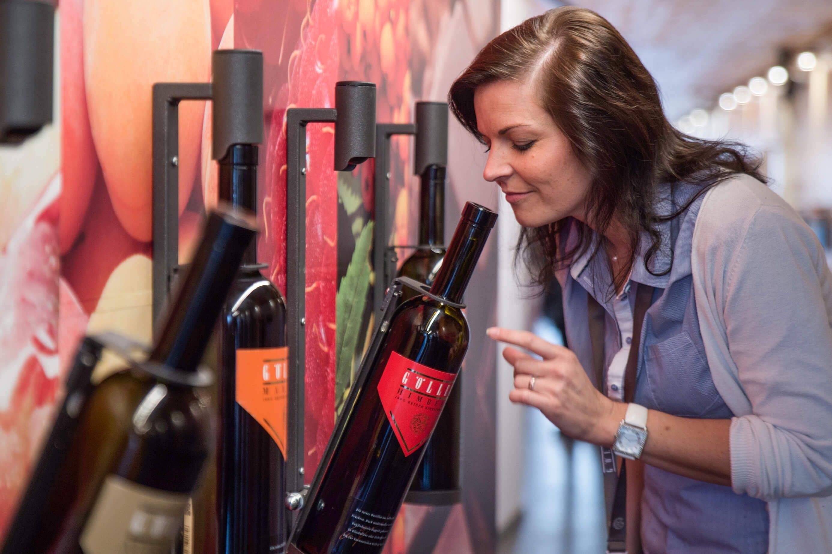 Eine Dame riecht an den Produkten der Essig- und Edelbrandmanufaktur.