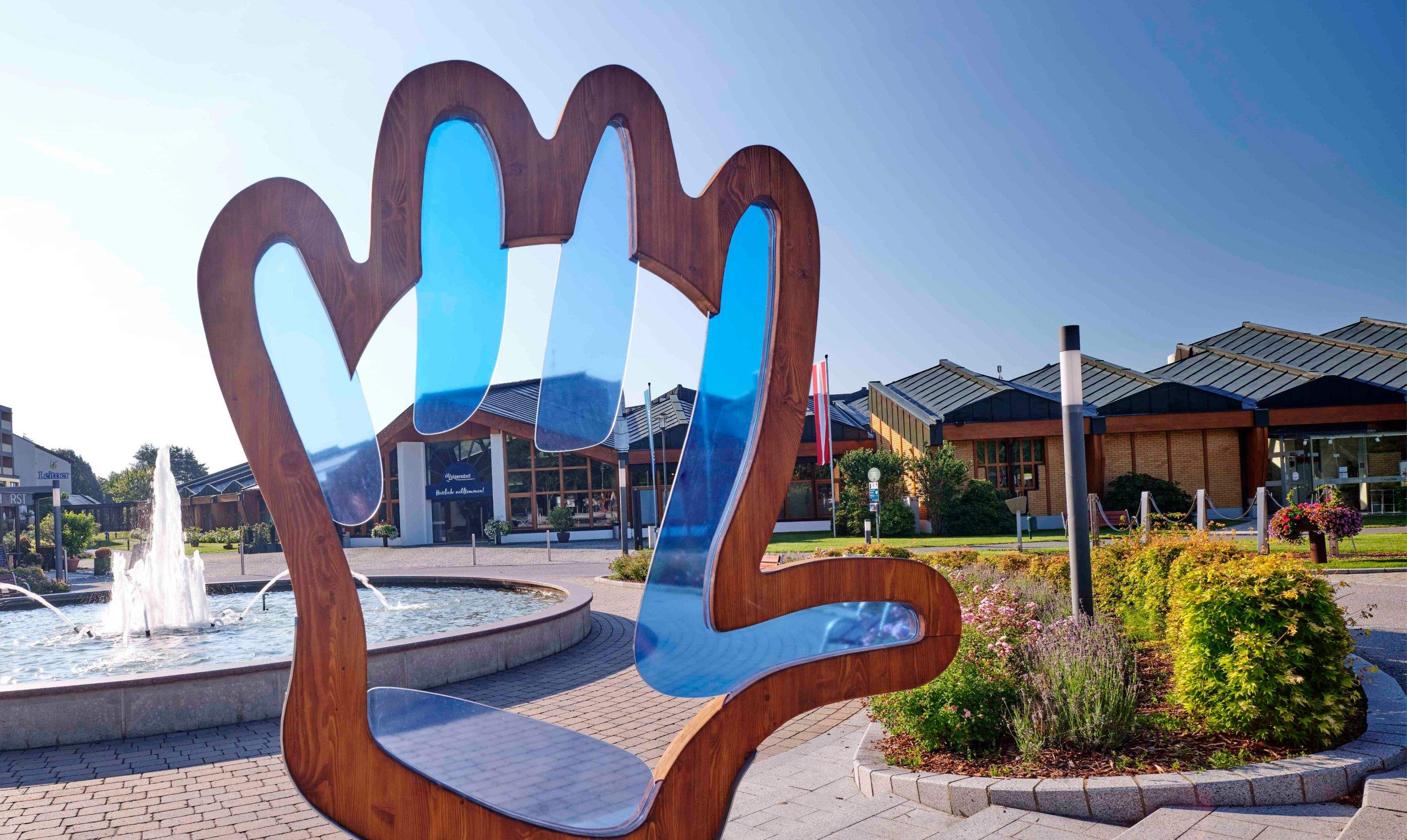 The forecourt of the Loipersdorf thermal spa resort with the logo hand as a sculpture.