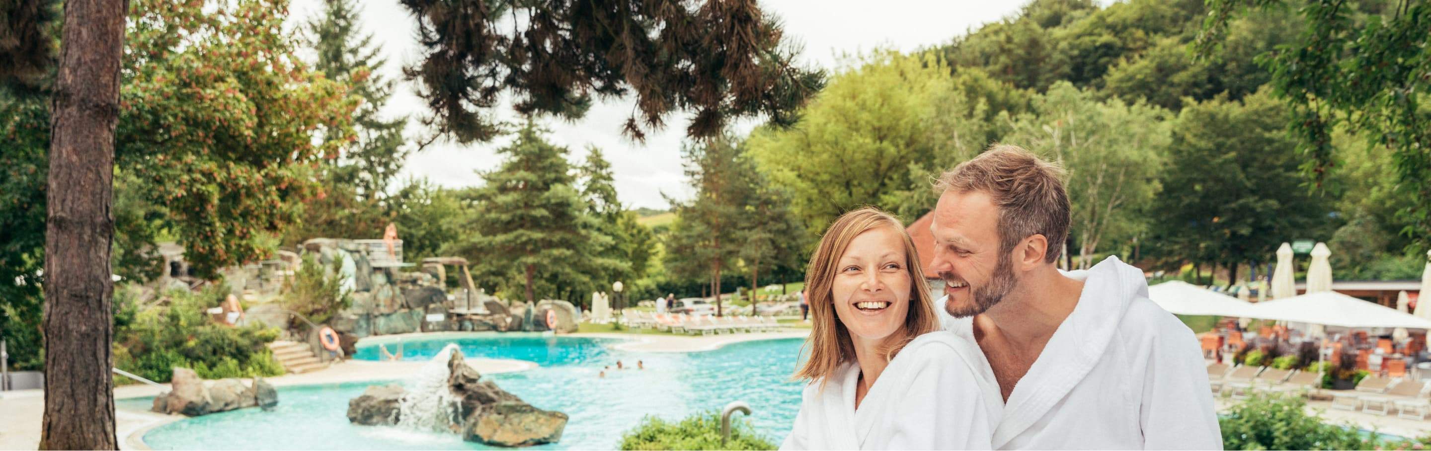 Couple in bathrobes in front of the Acapulco pool