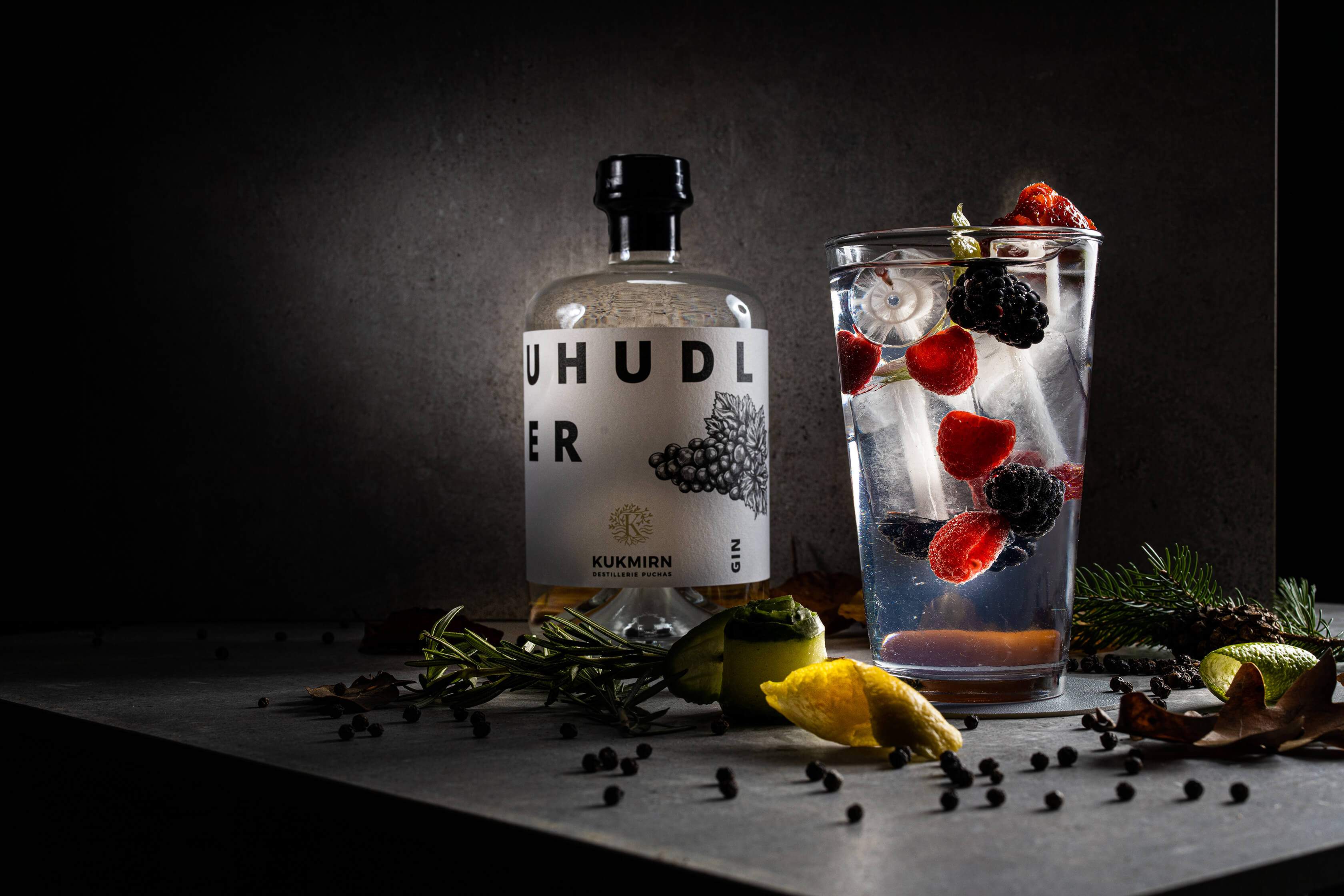 Ein Glas Gin Tonic mit einer Flasche Uhudlergin.