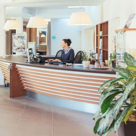 Eine Dame arbeitet an der Rezeption des Thermenresorts Loipersdorf.
