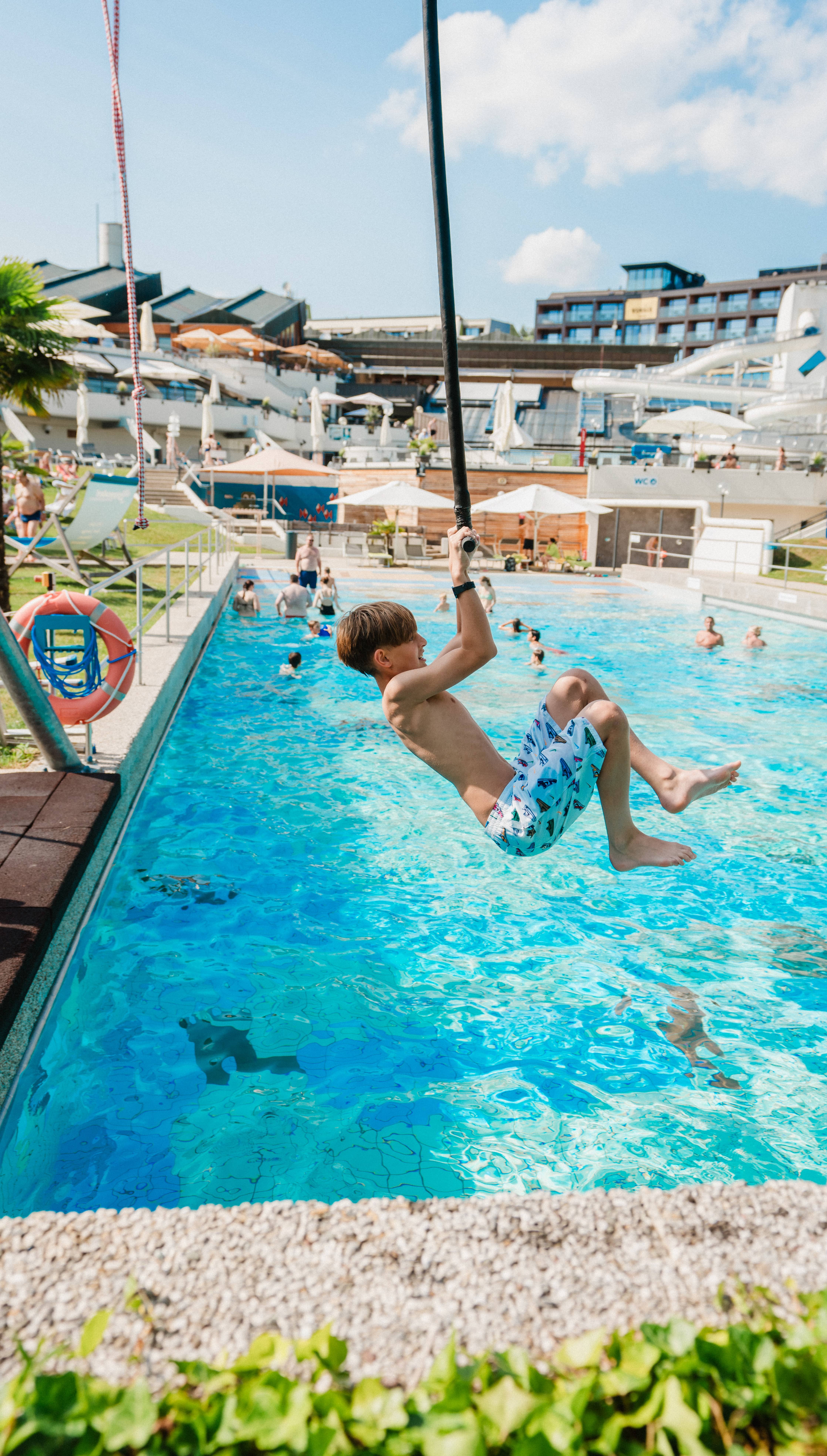 Kind flitzt mit der Affenschaukel über das Wellenbad.