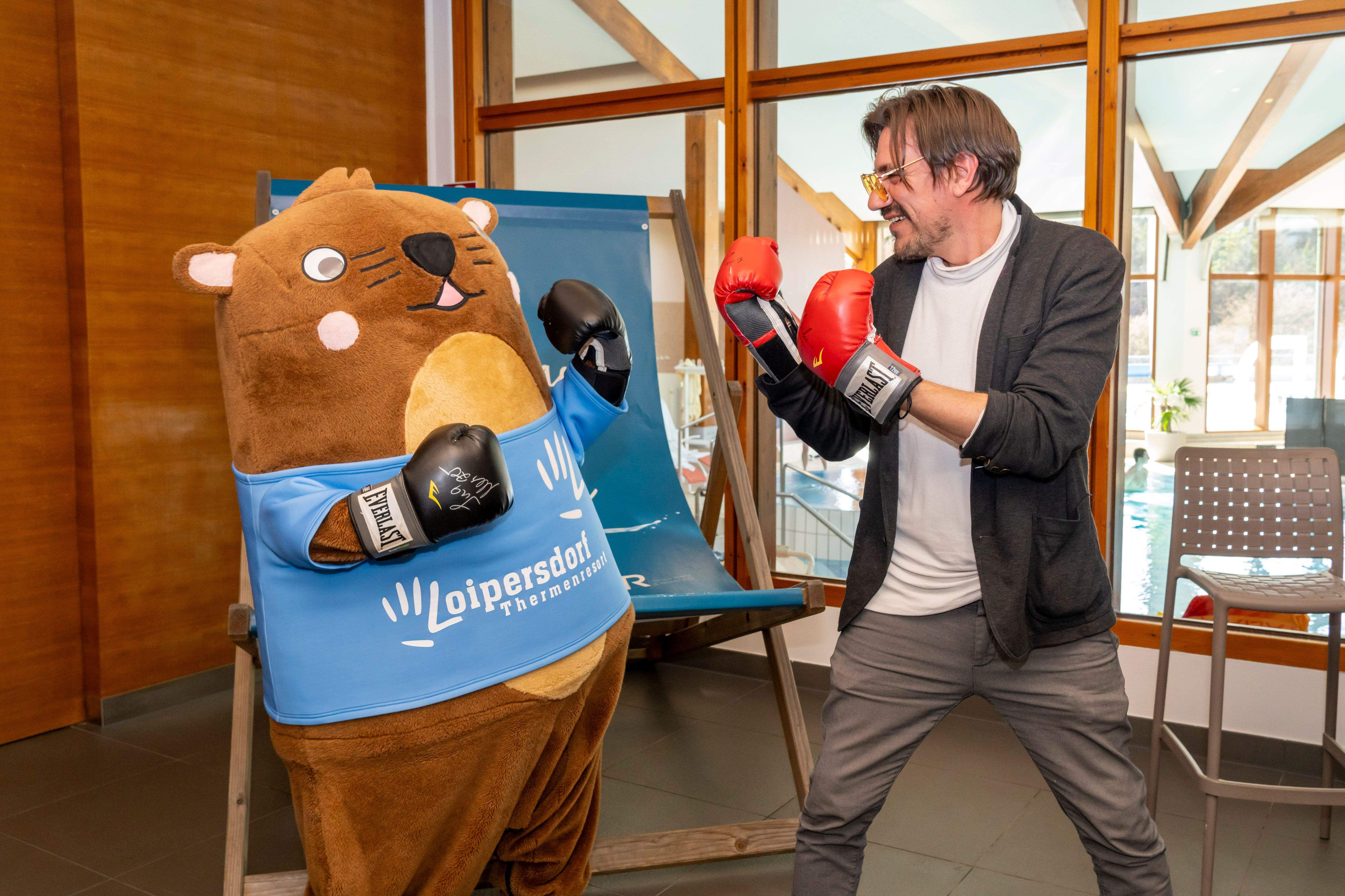 Maskottchen Otto und Christian Stani haben Boxhandschuhe an und stehen sich gegenüber. 