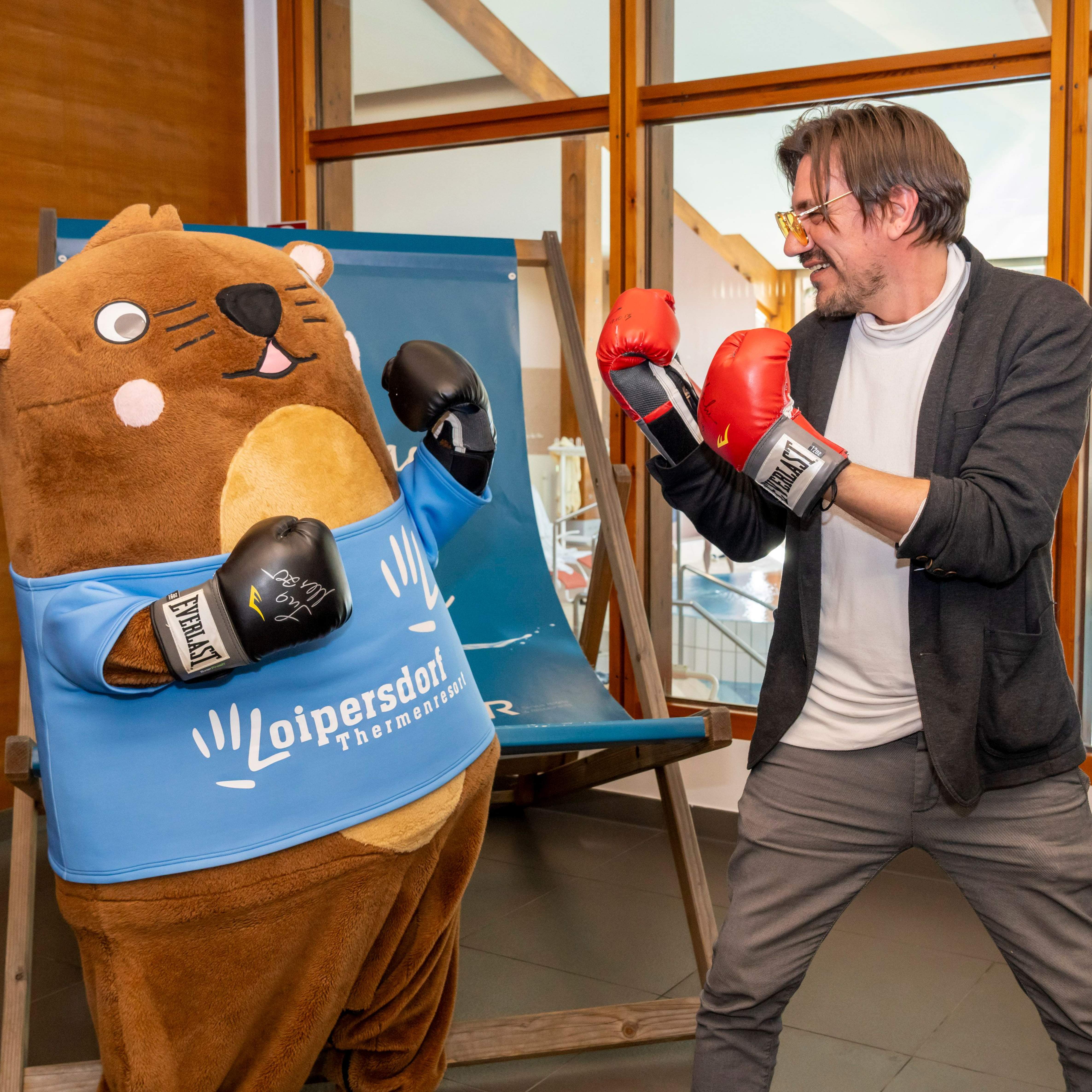 Mascot Otto and Christian Stani wear boxing gloves and face each other.