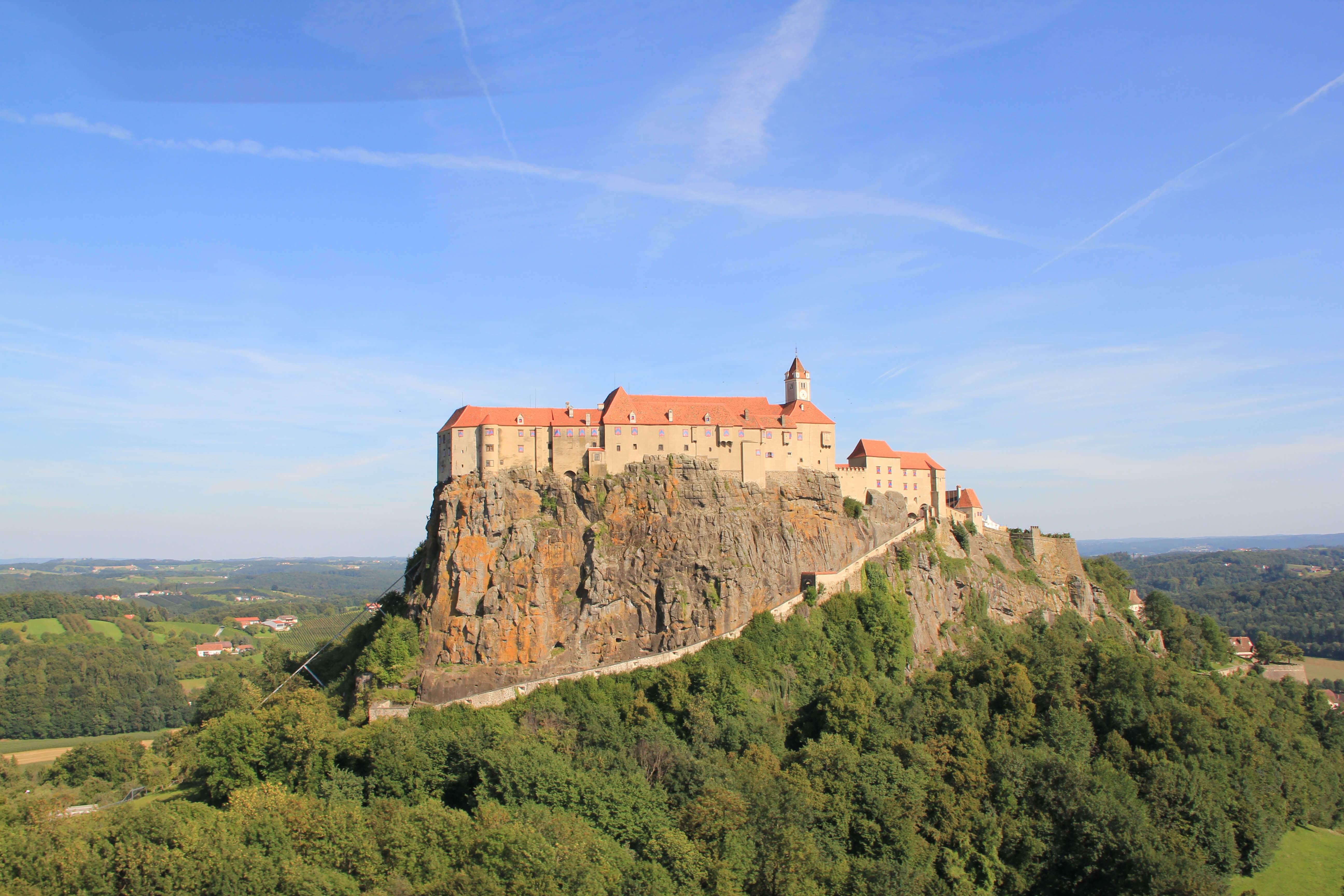 Riegersburg Castle from a distance under a bright blue sky.