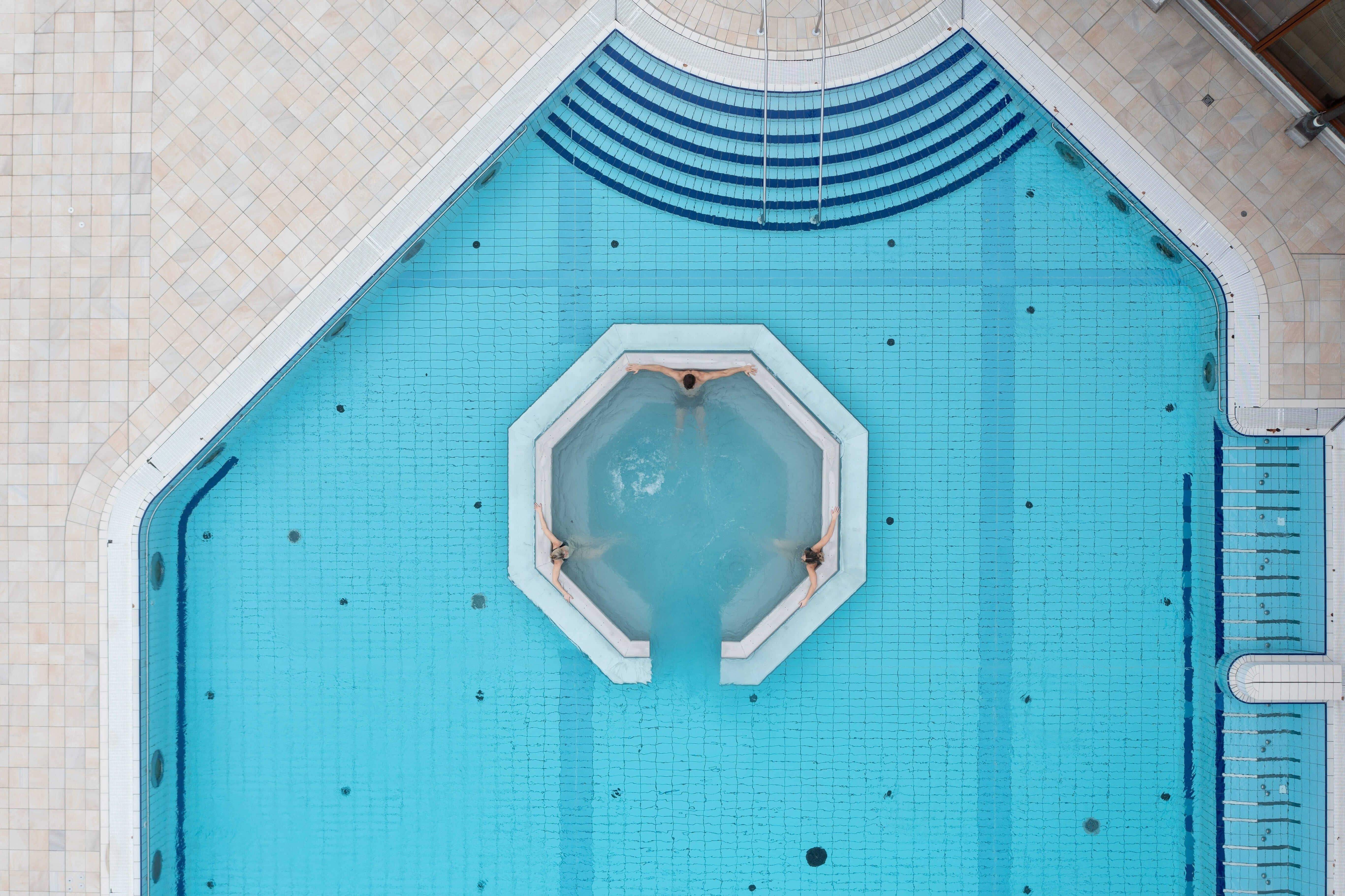 Drone view of the outdoor pool in the thermal spa. People in the thermal water can be seen from above.