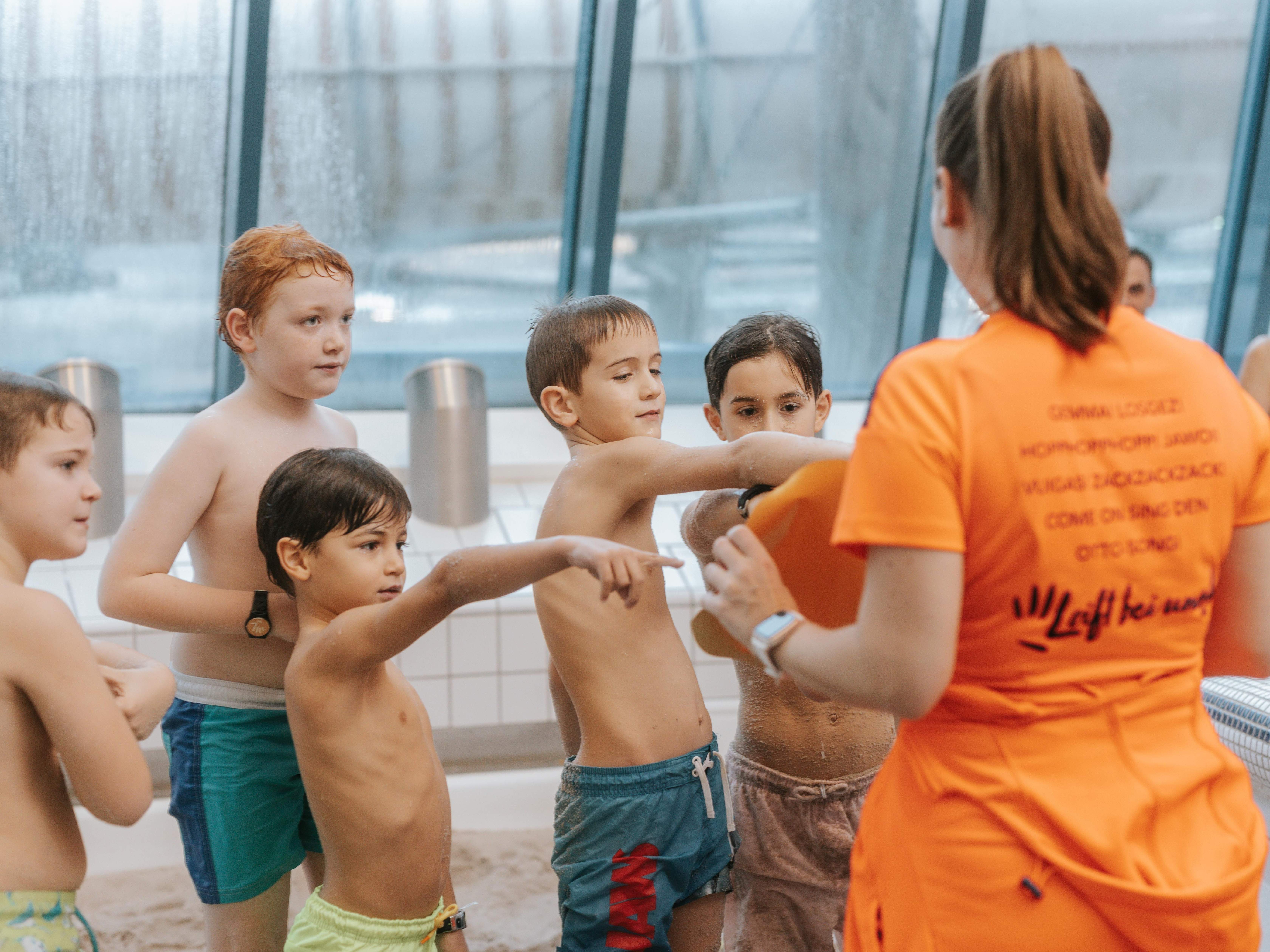 Kinder zeigen bei einem Animations-Mitarbeiter auf eine Karte. 