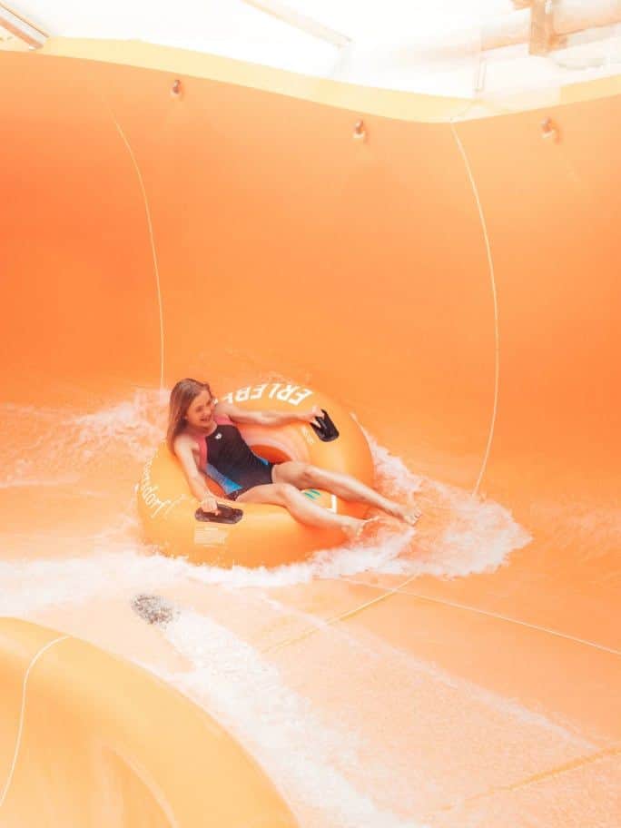 Kind rutscht in einem Reifen die Rutsche runter