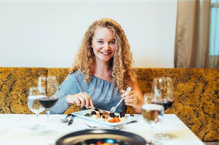 Eine Frau welche ein After-Work-Dinner genießt.