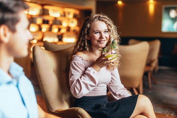 Eine Frau die einen Cocktail in der Sunny Bar genießt. 