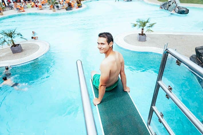 Ein Mann der auf einem Sprungbrett sitzt.