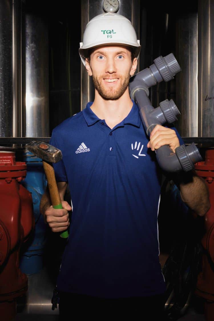 Ein Handwerker mit Rohr und Werkzeug.