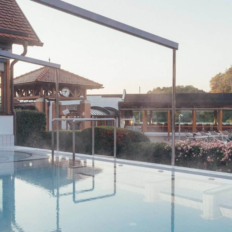 A view across the courtyard pool into the greenery of the Schaffelbad.