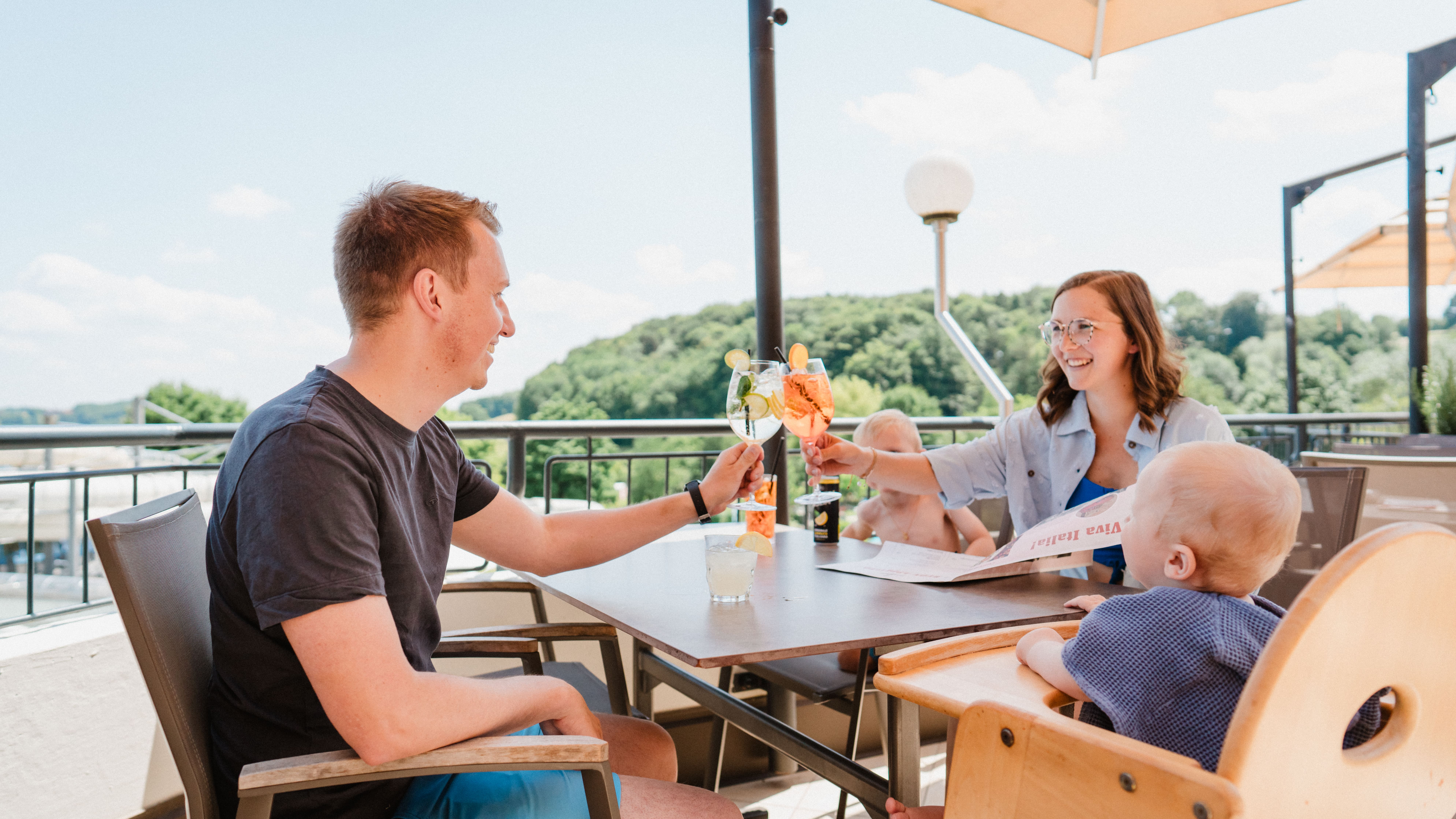 Eine Familie genießt die Sonne auf der Don Camillo Terrasse. 