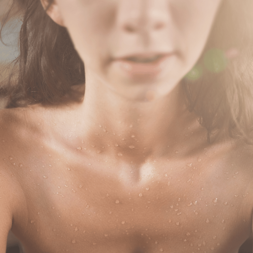 Eine Frau sitzt in der Sauna und schwitzt