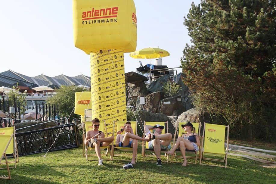 Drei Männer und eine Frau chillen in den Antenne Steiermark Liegesesseln 