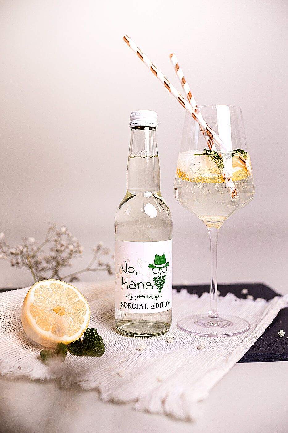 A drinks bottle and a drink are placed on a blanket.