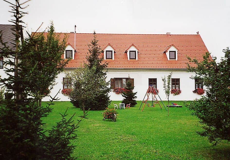 Das Gästehaus Brückler von außen mit Garten und Spielplatz.